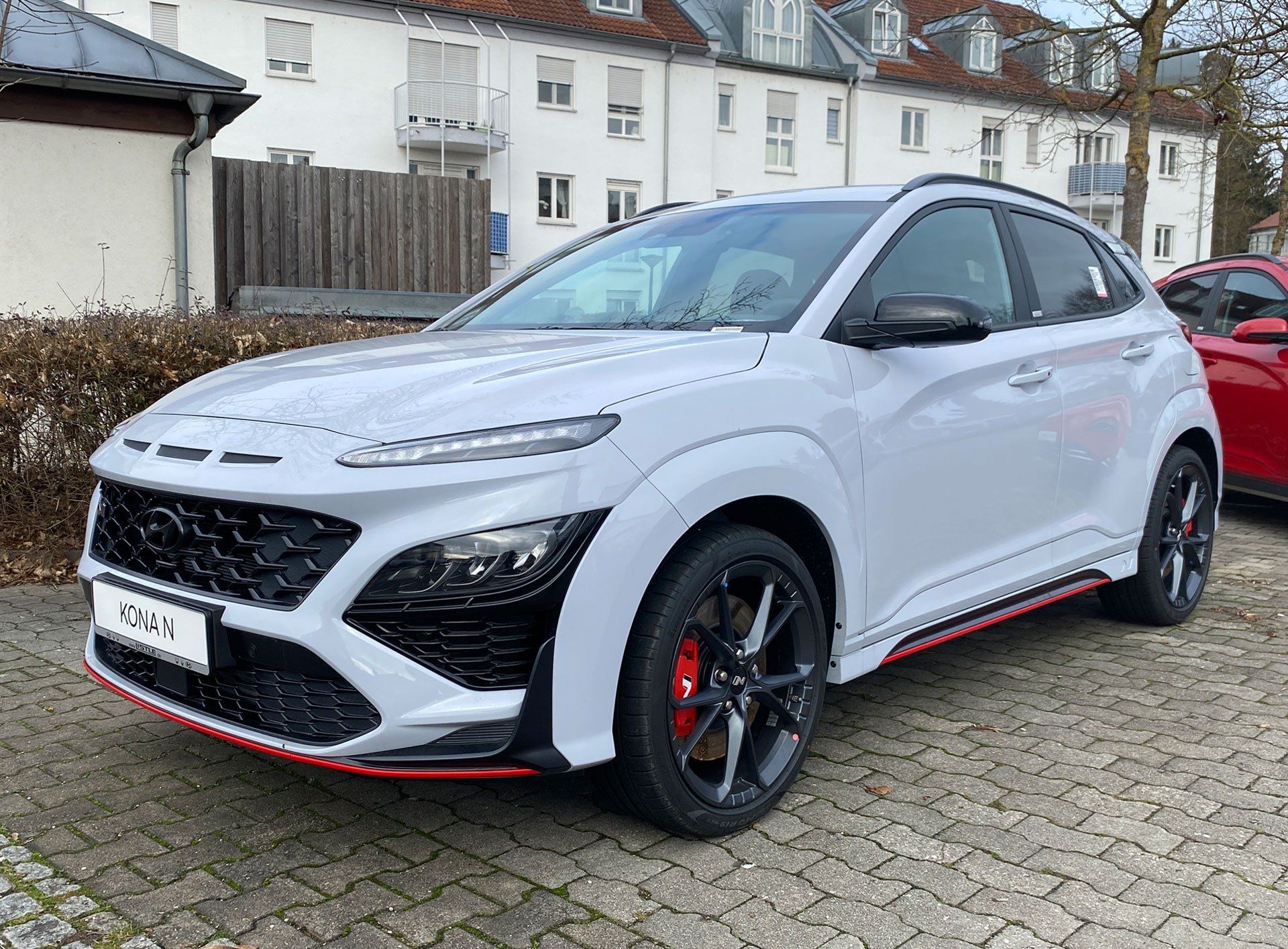 White sporty SUV with red accents parked on a residential street