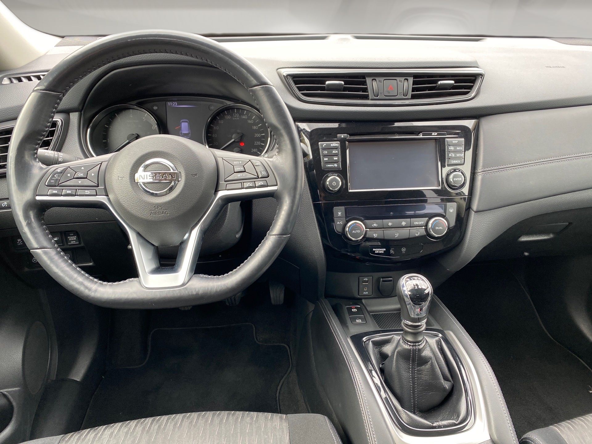 Interior shot with window blur Interior of a Nissan car, showing the steering wheel, center console, dashboard, and manual gear shift