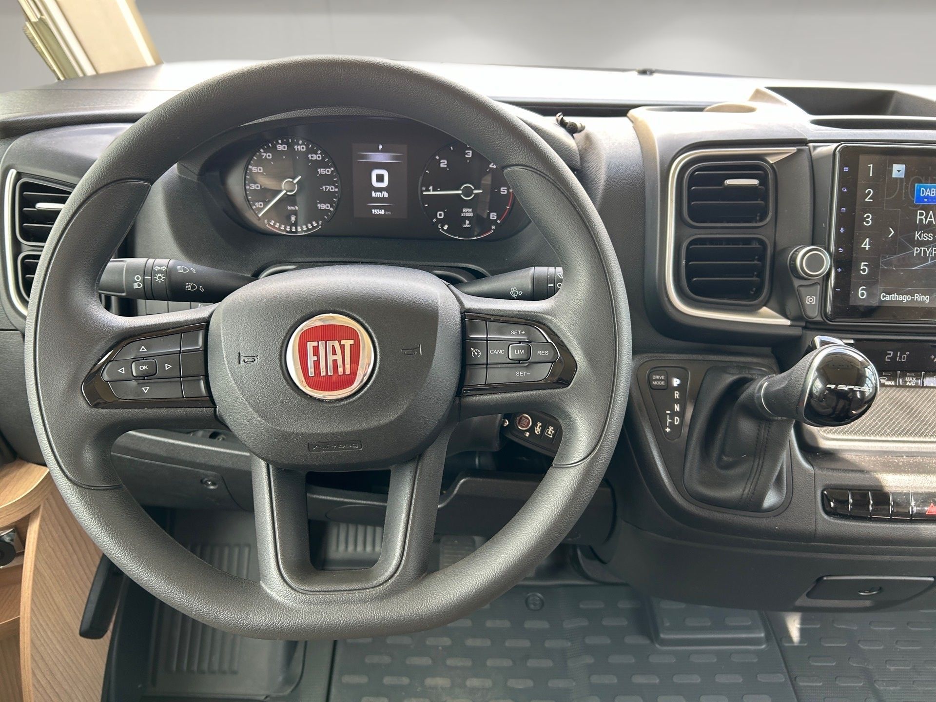 Interiér auta Fiat s volantom, palubnou doskou, stredovou konzolou a manuálnou radiacou pákou