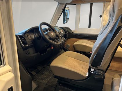 Der Innenraum eines Wohnmobils mit Lenkrad und Sitzen.