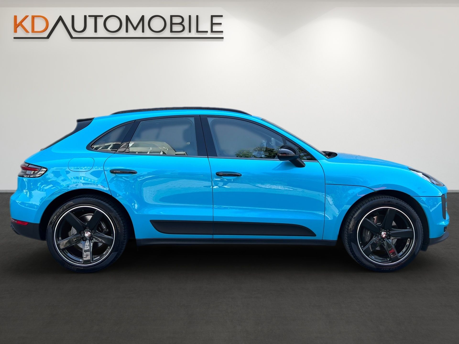 Bright blue sporty SUV in side view on a studio backdrop with KD Automobilе branding