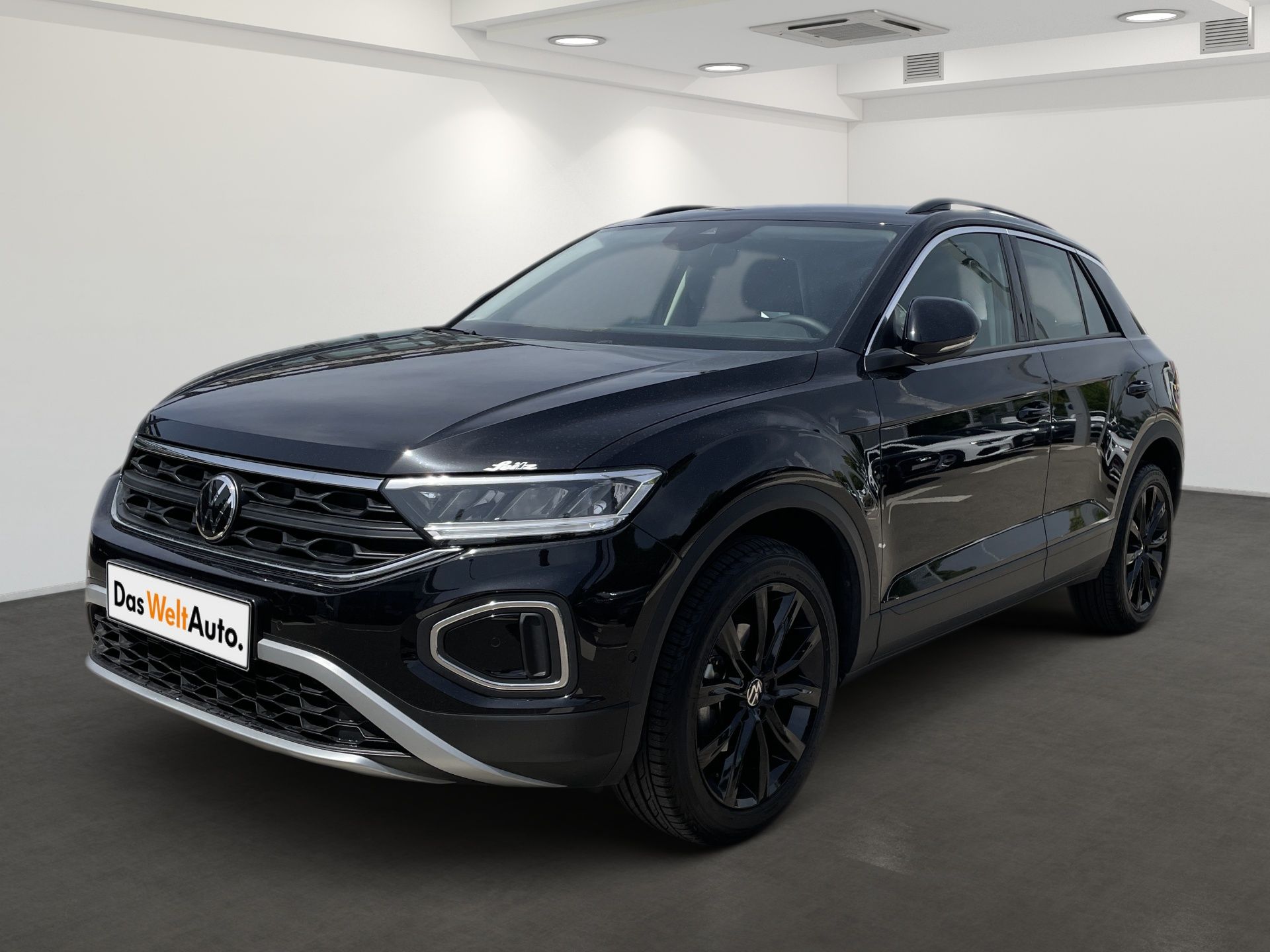 Black SUV in a showroom, viewed from the front-left side.