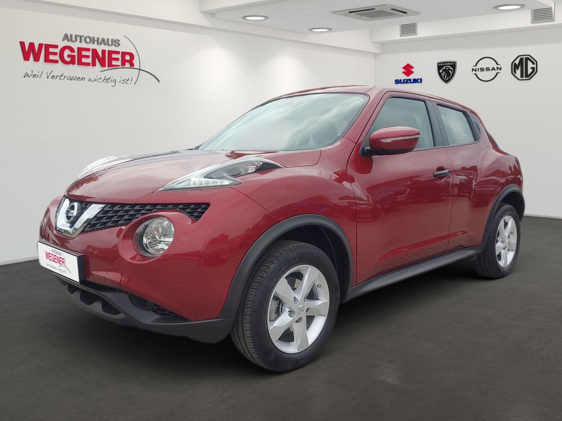 Roter Kompakt-SUV im Ausstellungsraum, Seitenansicht, mit roter Karosserie und silbernen Felgen