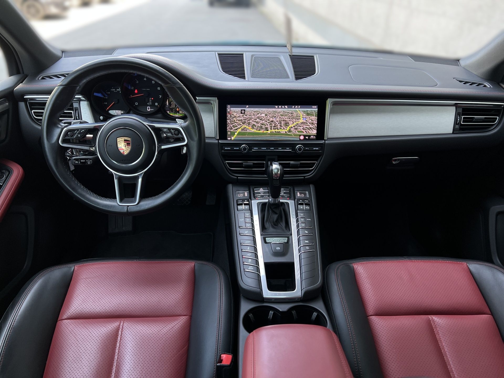 Luxury Porsche interior with red leather seats, dashboard, and center console view