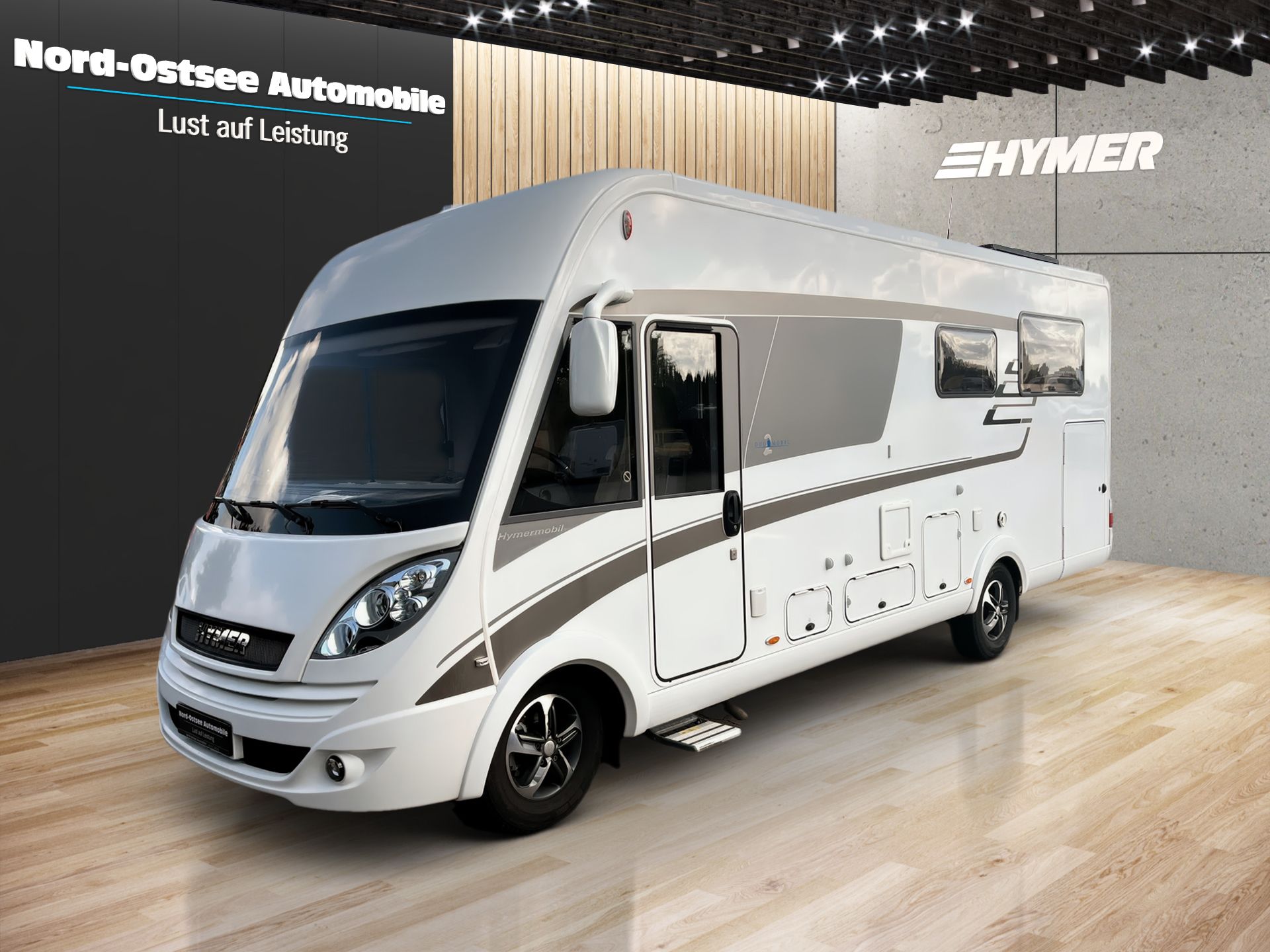 Biely obytný automobil Mercedes vystavený v krytej predajni s drevenou stenou v pozadí