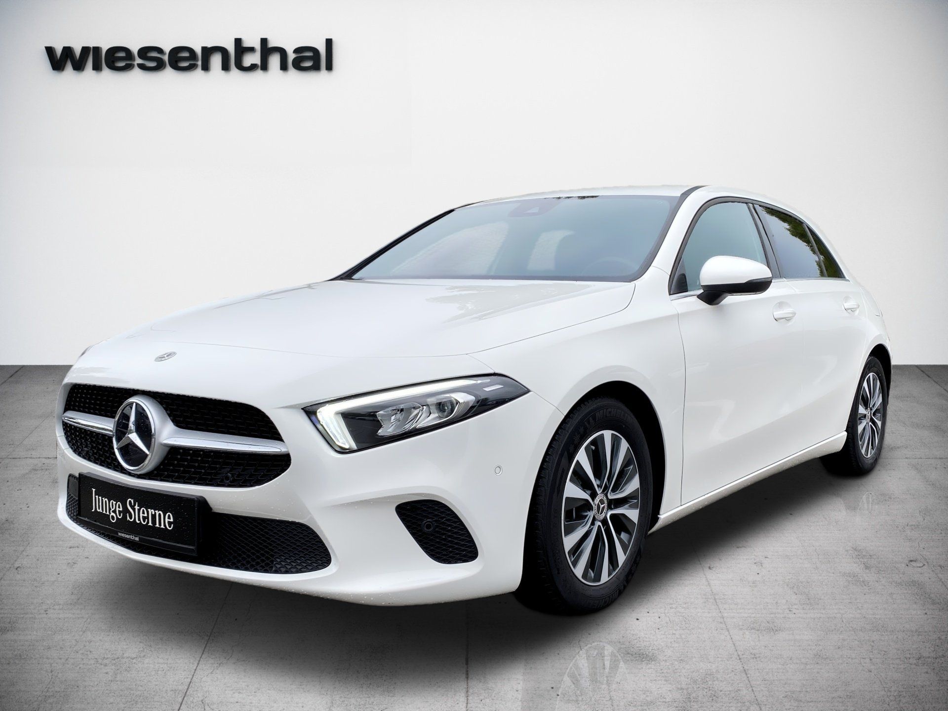 Biely hatchback Mercedes-Benz na pozadí štúdia s logom Wiesenthal v rohu