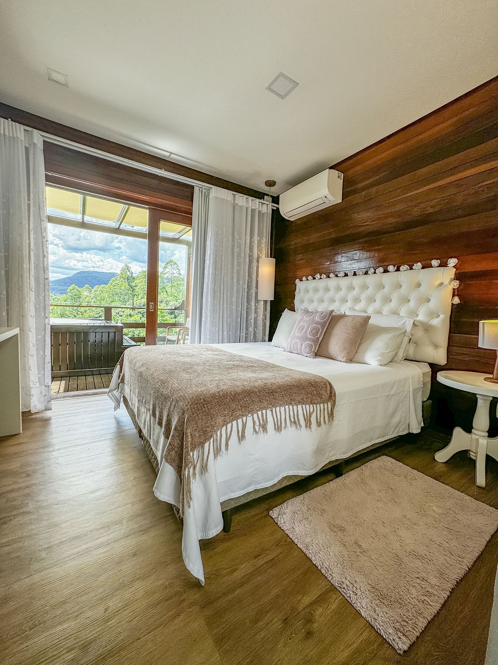 Uma sala com sofá, cadeiras, mesa e televisão.