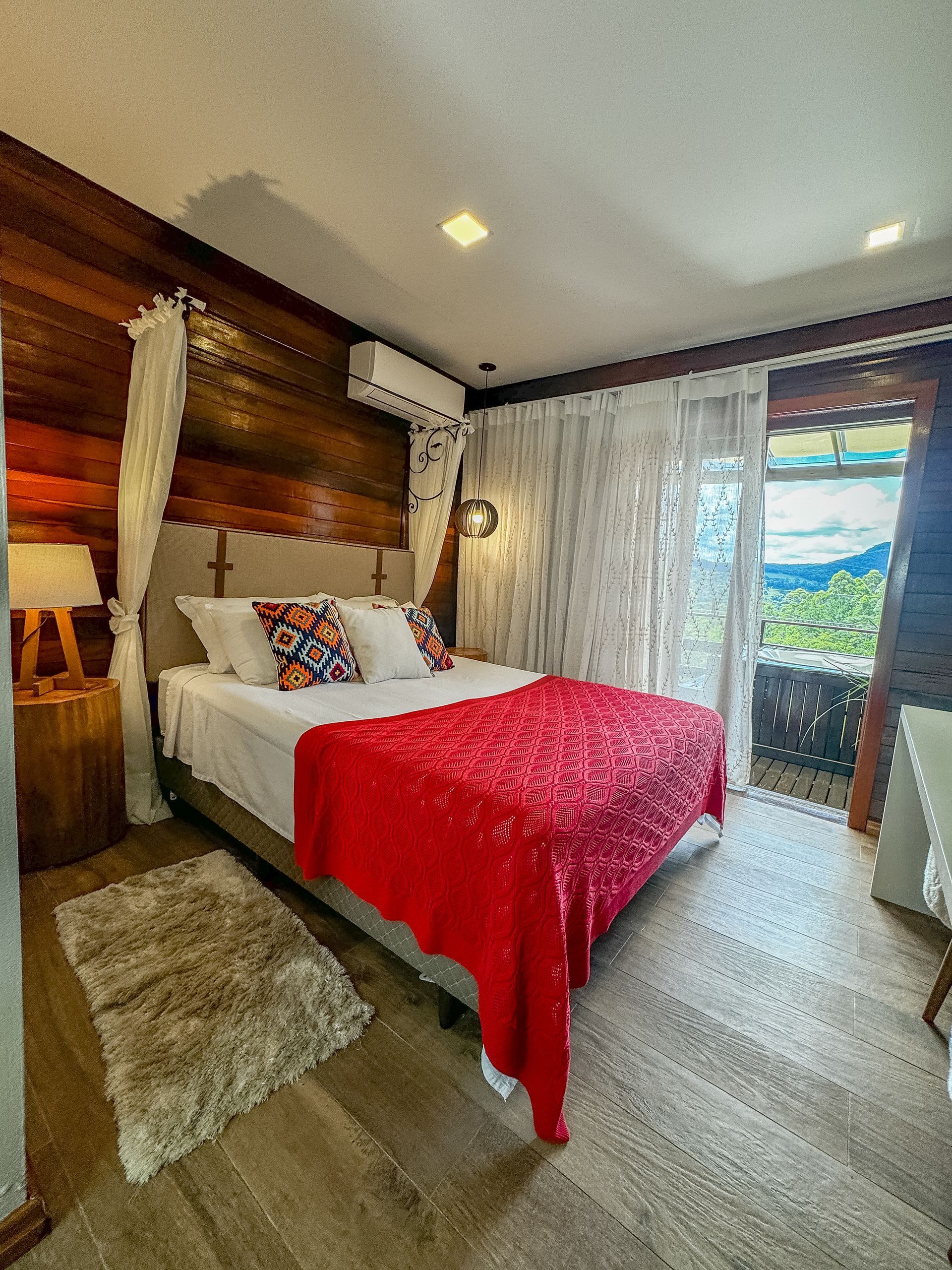Um quarto com cama e mesa de cabeceira com flores na parede.