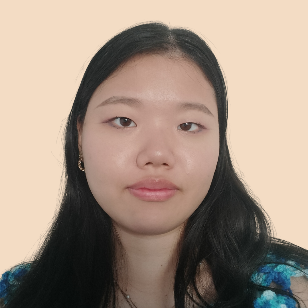 Close-up portrait of a woman with long dark hair against a plain beige background