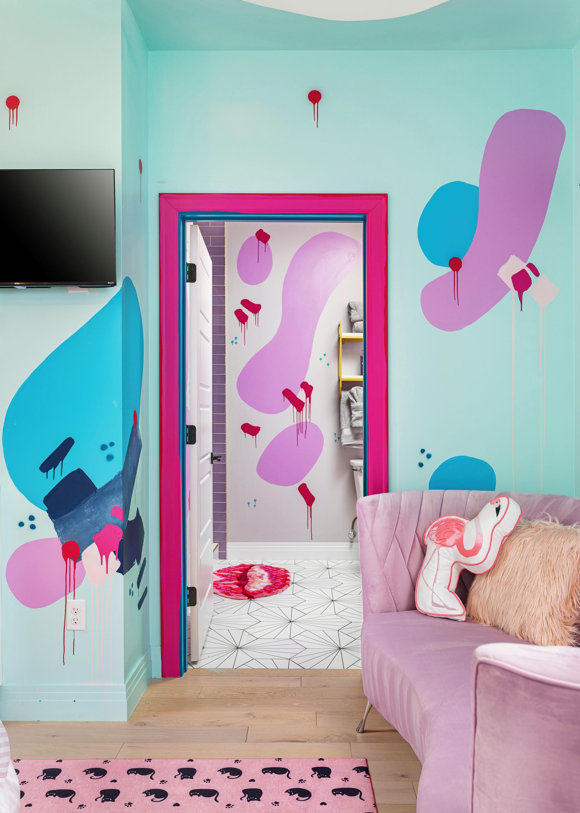 Pastel pink and blue children's bedroom with butterfly wall decals, mirror, and bed with stuffed toys
