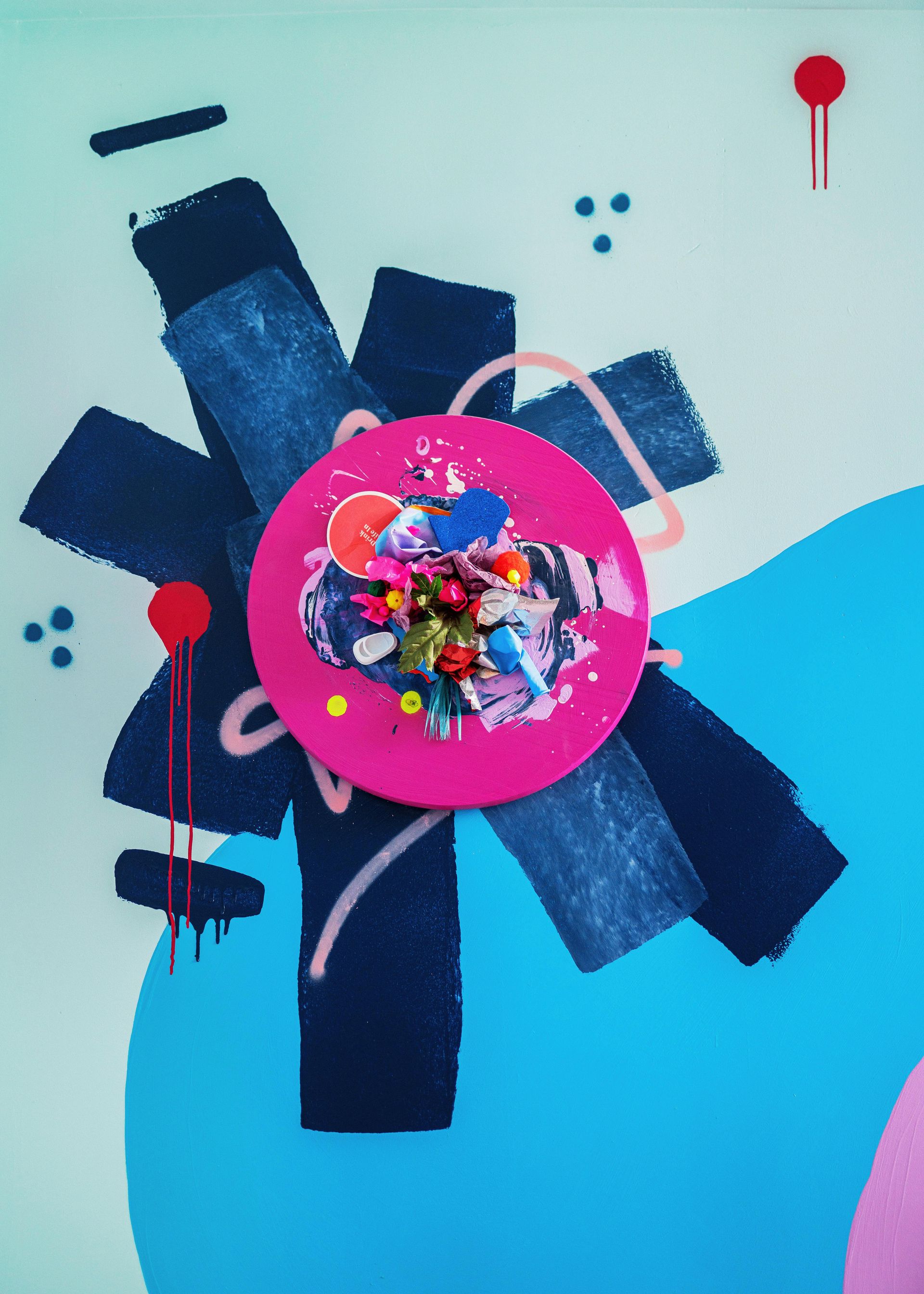 Abstract collage with dark blue tape, pink circle, and colorful confetti on a light blue background