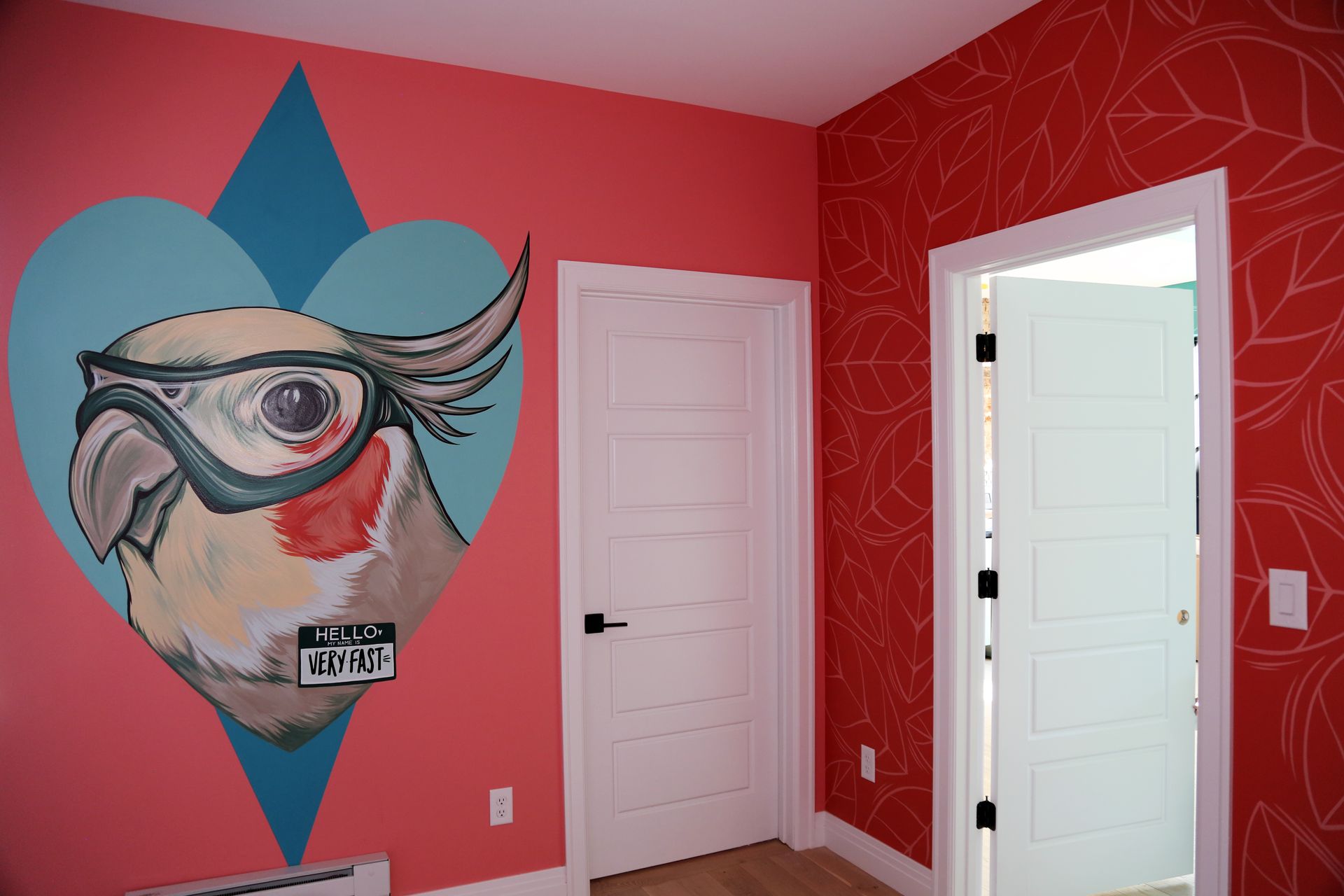 Colorful bedroom wall mural with a large eye illustration and two white doors on red and pink walls