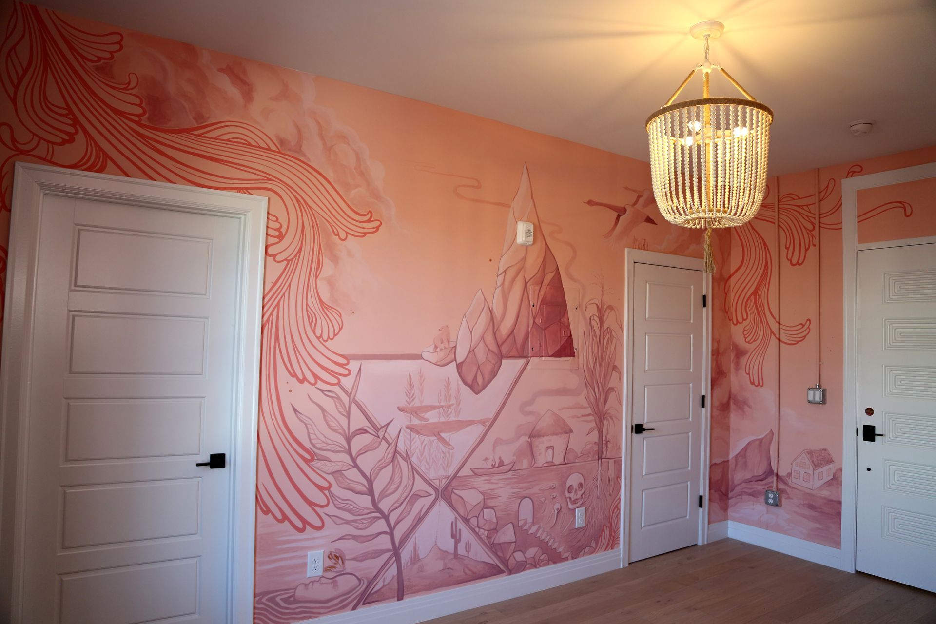 Pink bedroom with horse mural wallpaper, three white doors, and a hanging chandelier