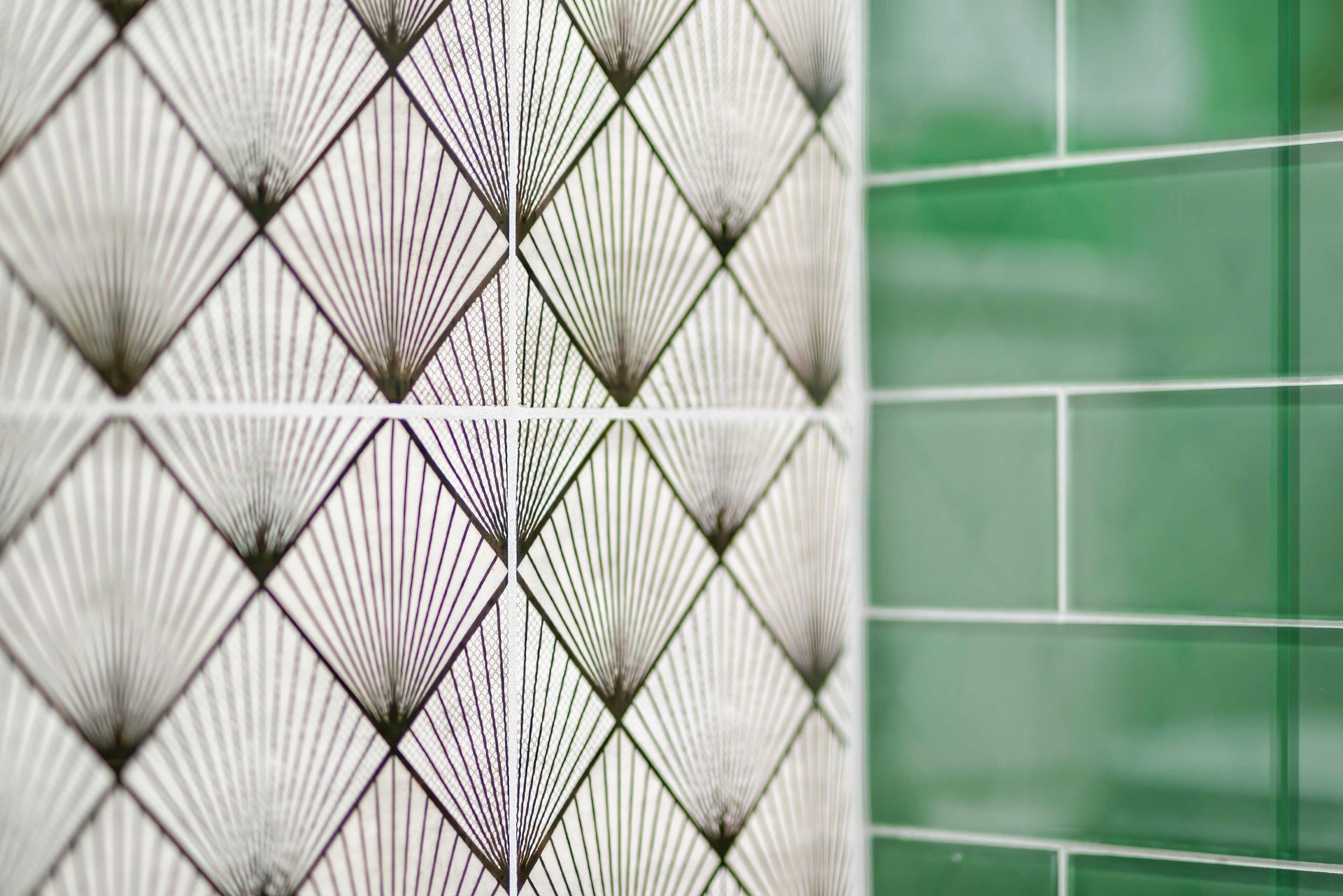 Patterned white and green tiled wall with diamond grid and horizontal lines