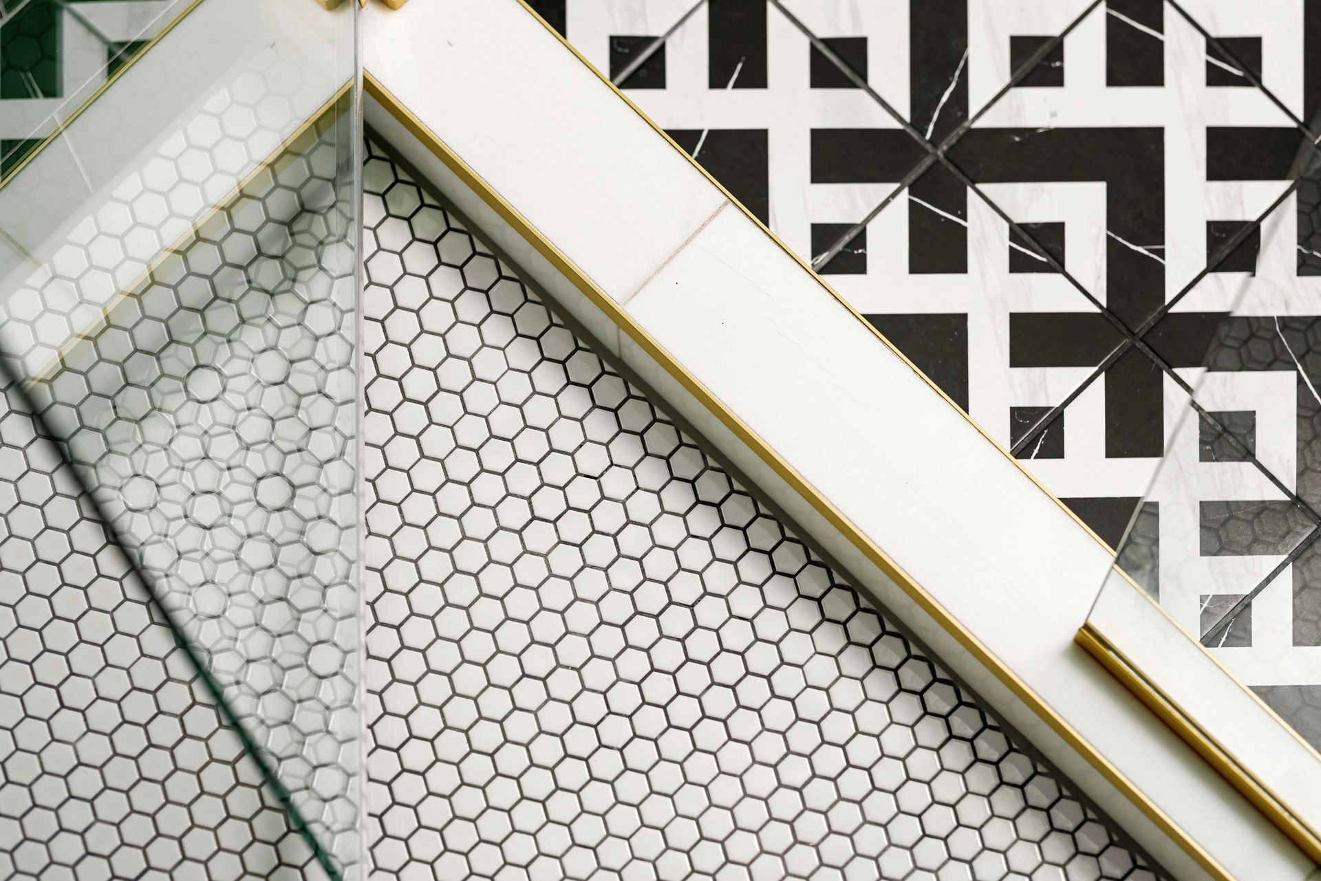 Geometric black-and-white tile and mosaic wall with diagonal gold-trimmed white beams