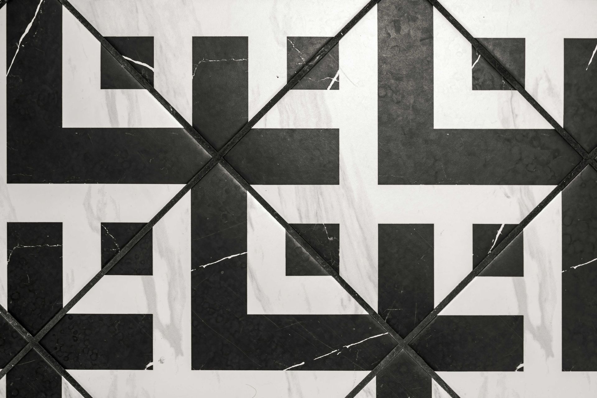 Black-and-white geometric tile pattern with repeating squares and diagonal lines