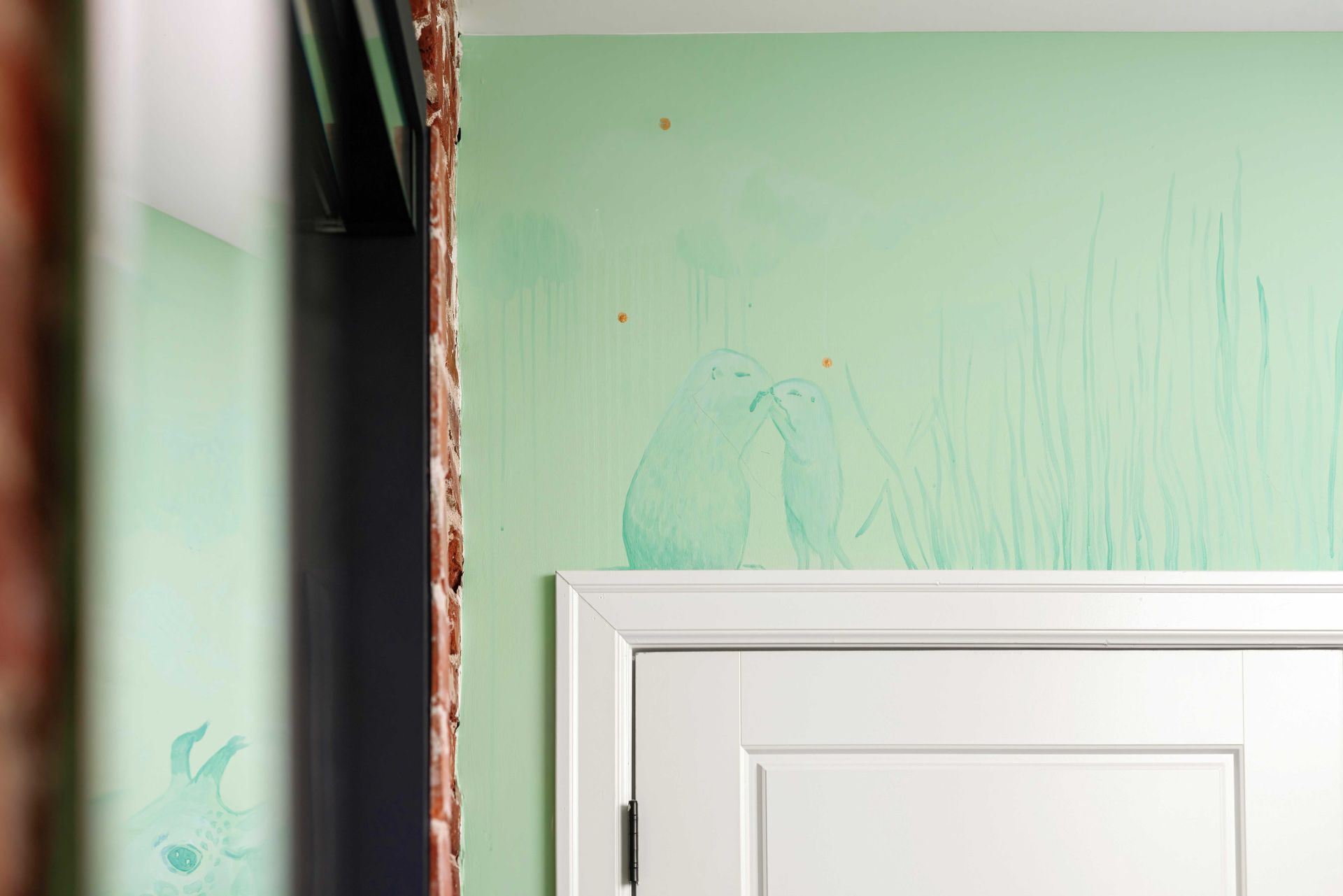 White doorframe against mint-green wall with peeling paint and exposed trim work
