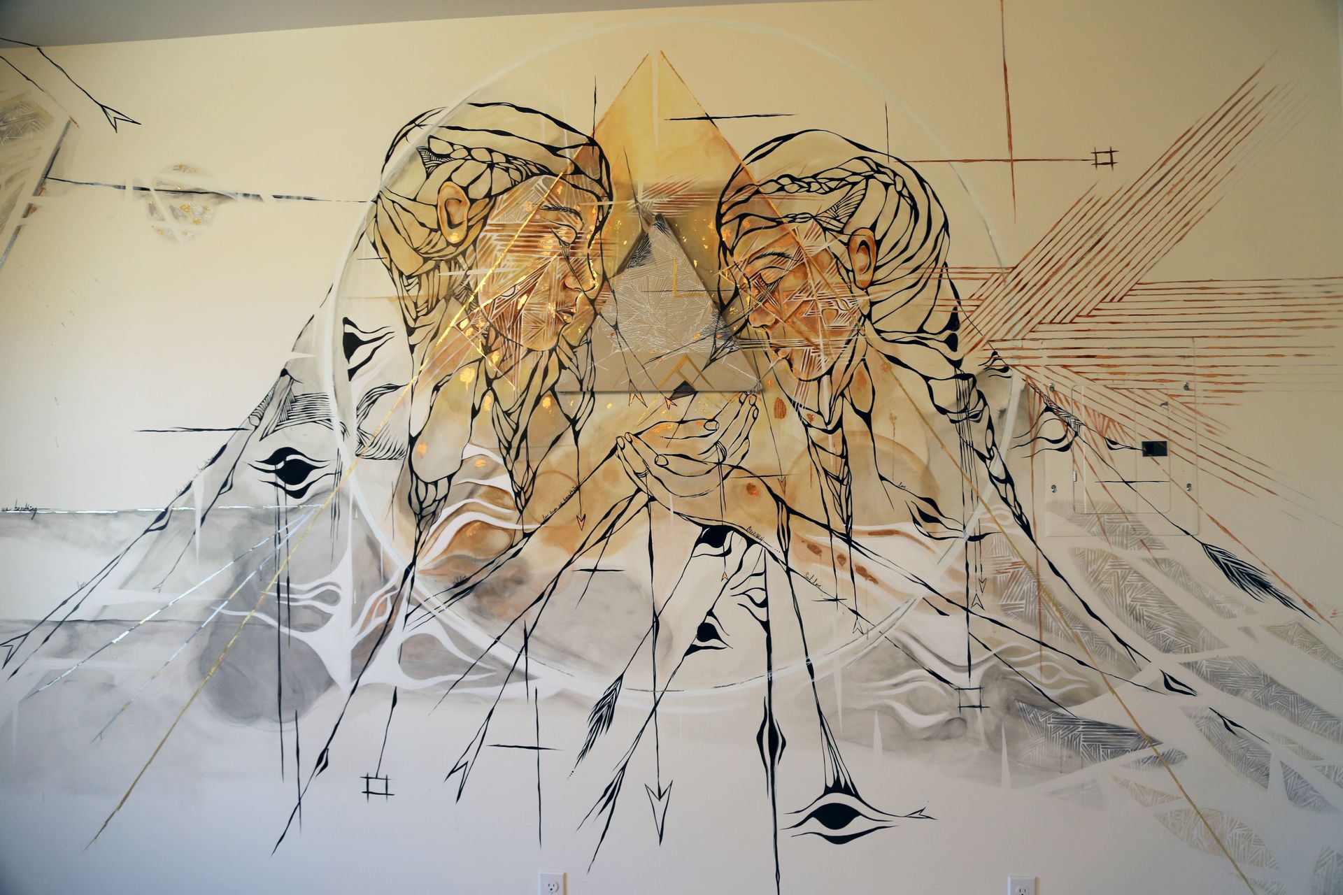 Abstract sketch of two tiger faces with orange, black, and white geometric lines on a pale background