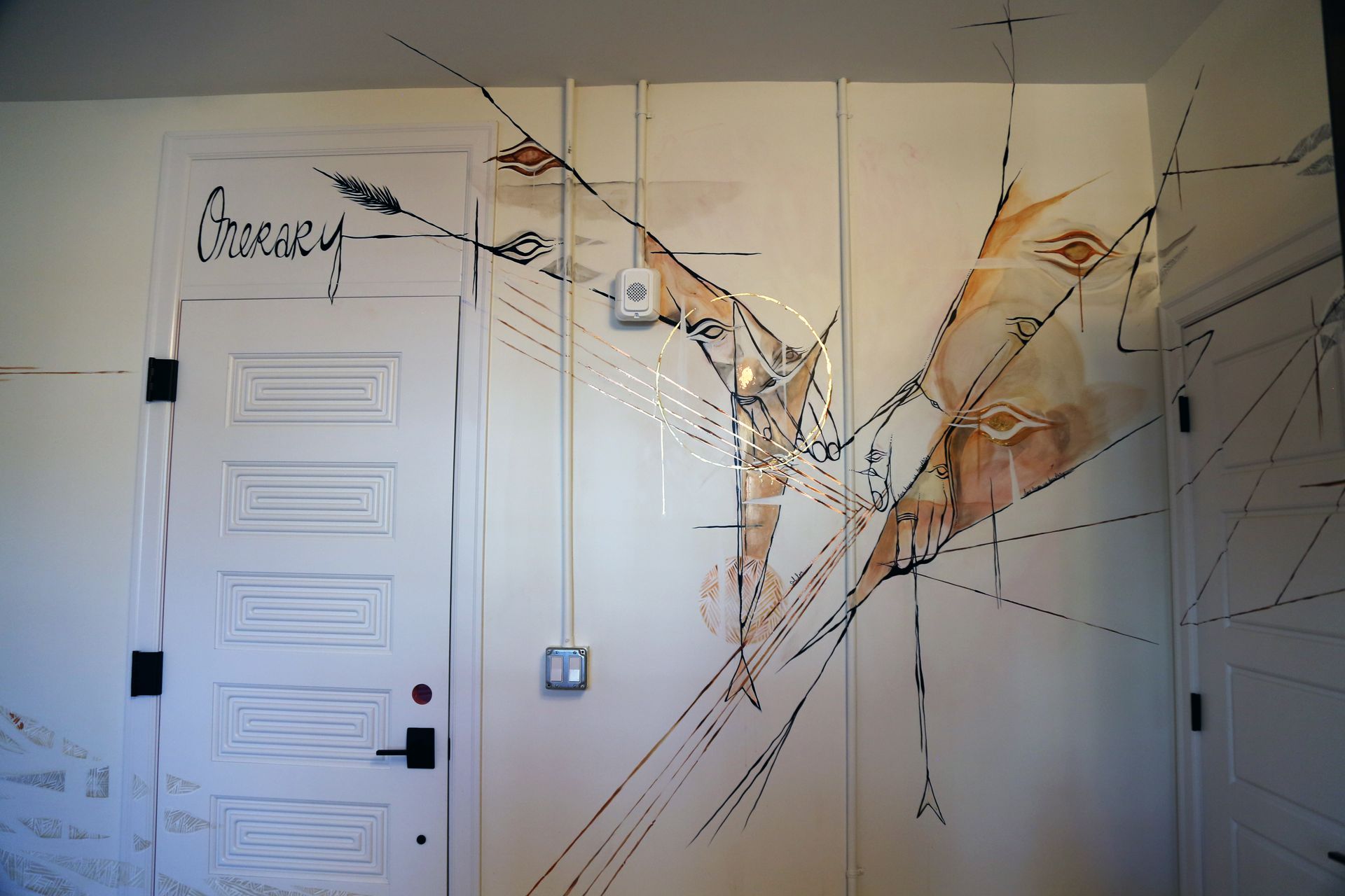 Wall with large cracks and shattered plaster around a white door and electrical outlet
