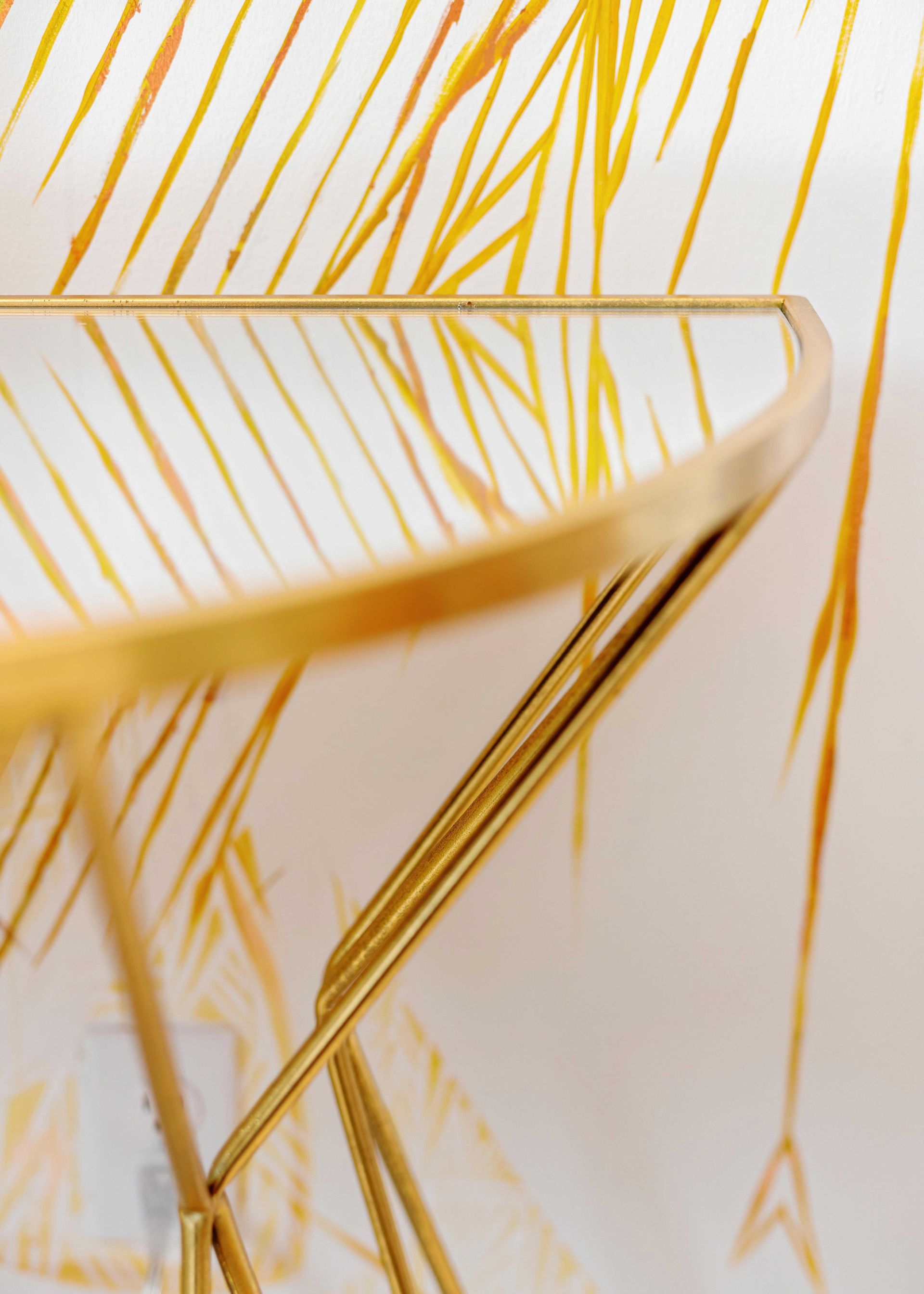 Gold wireframe chair on a white background with yellow abstract lines.