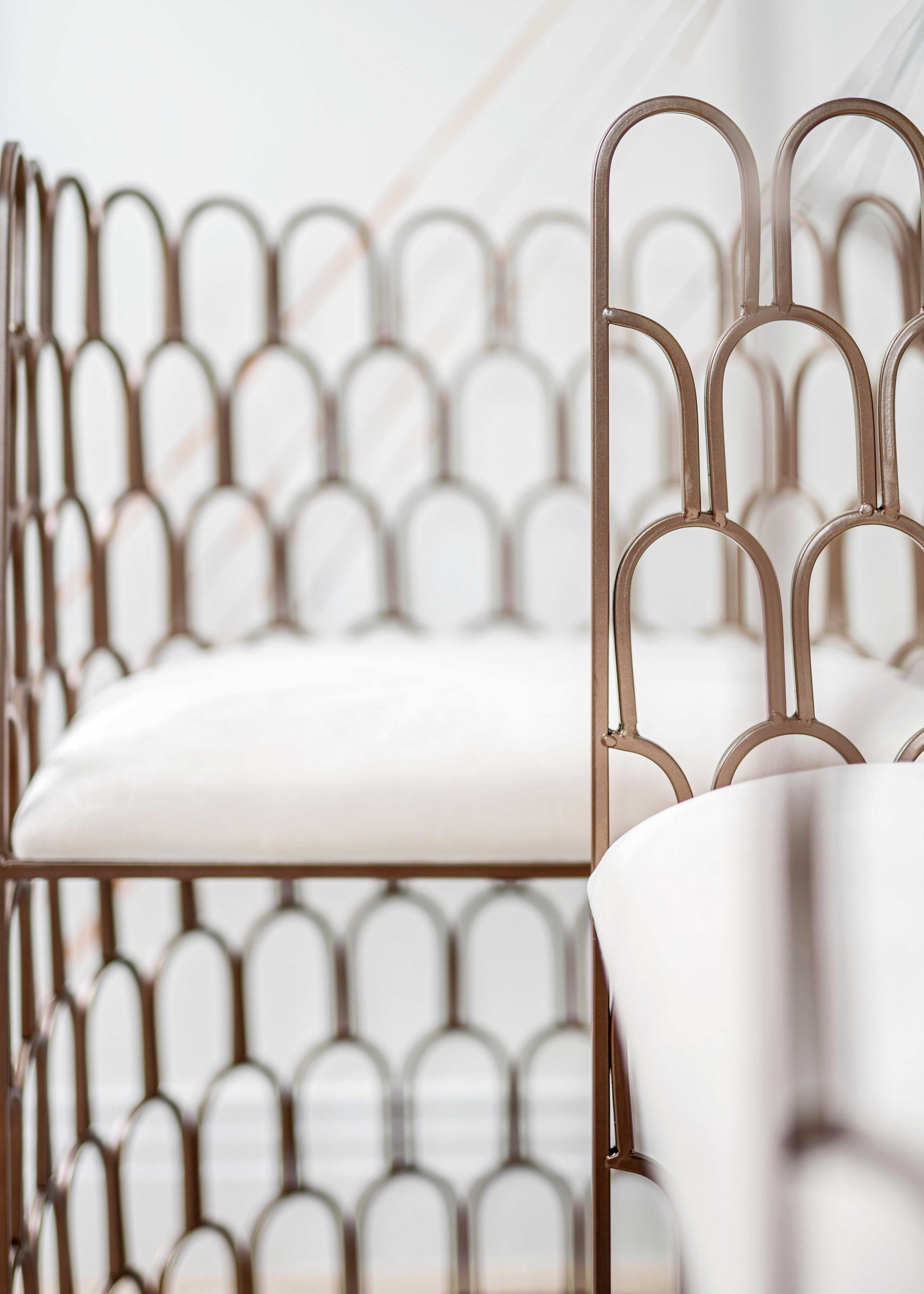 White chairs with woven brown backs arranged in a bright, minimalist room