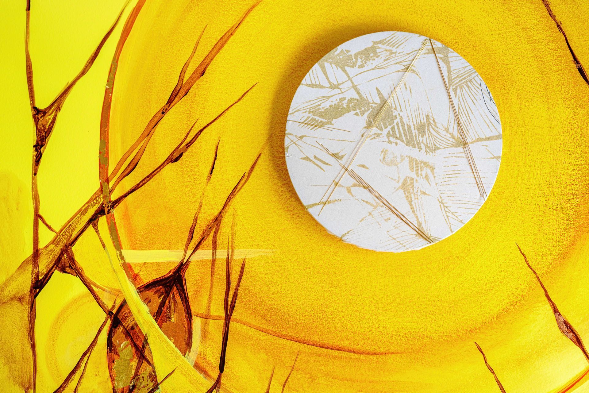 Yellow abstract background with a white circular center and brown branching lines