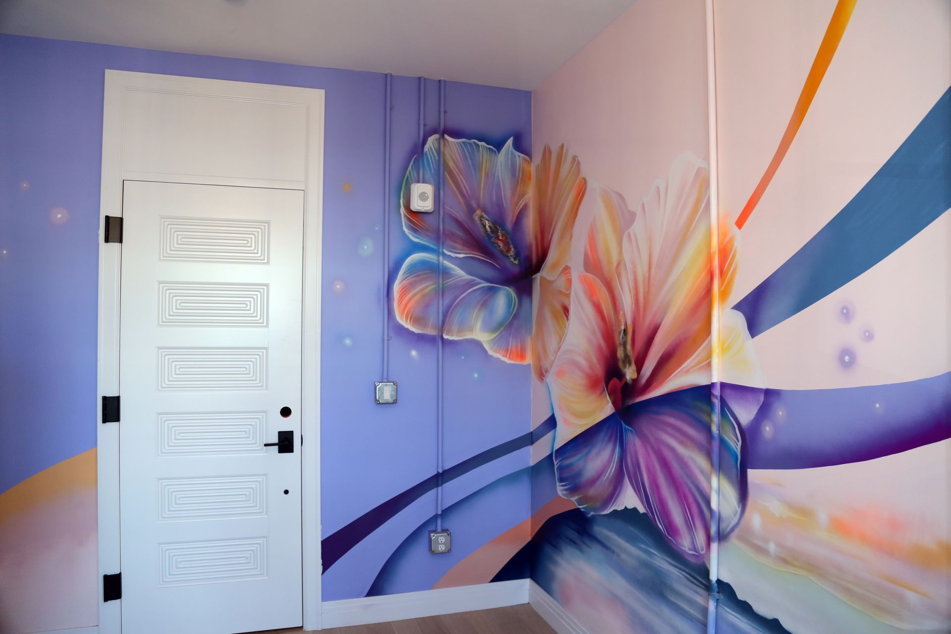 Lavender room with a white door and colorful butterfly mural on the wall