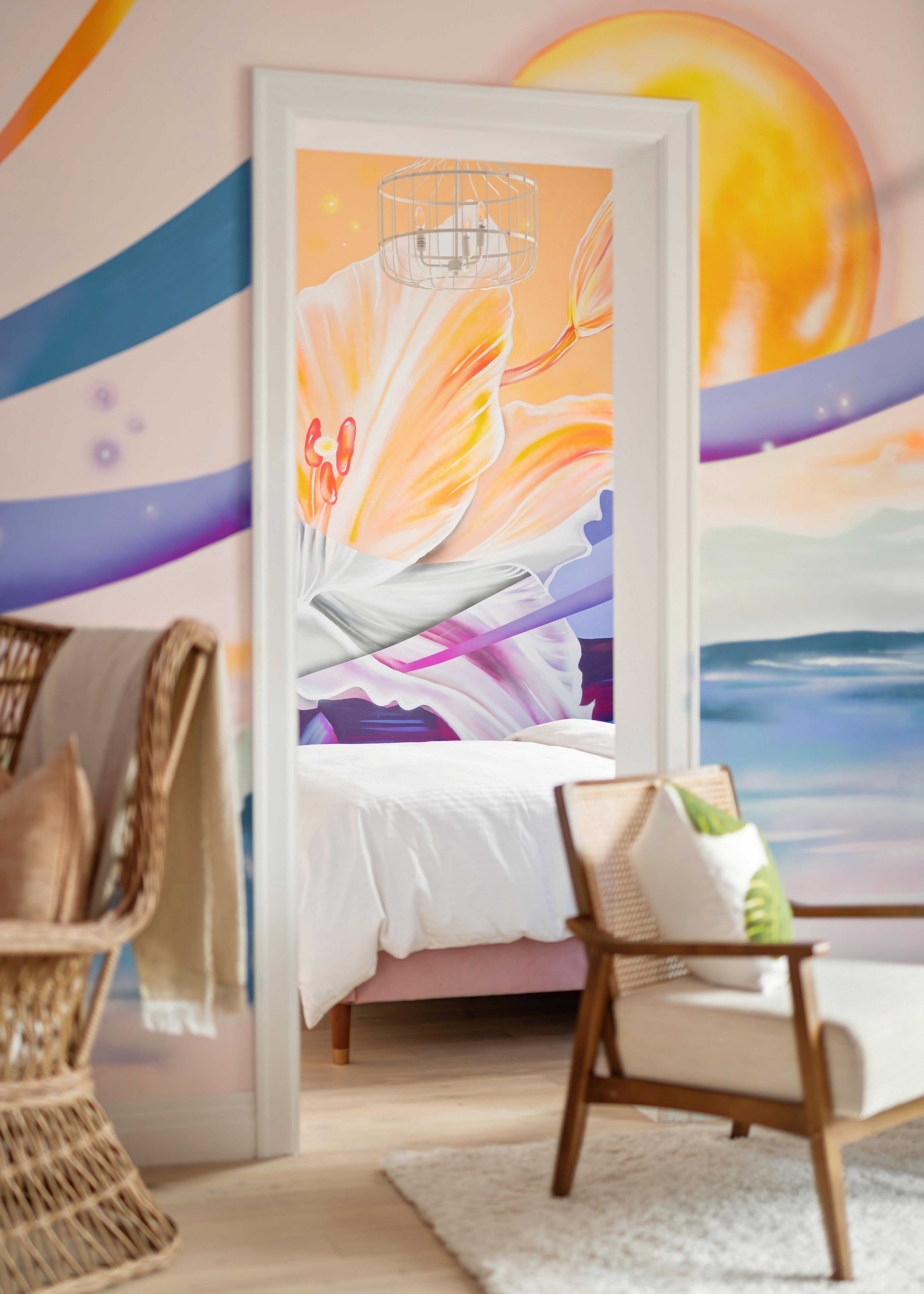 Bright bedroom with abstract mural, white bed, wicker chair, and sunlit ocean view