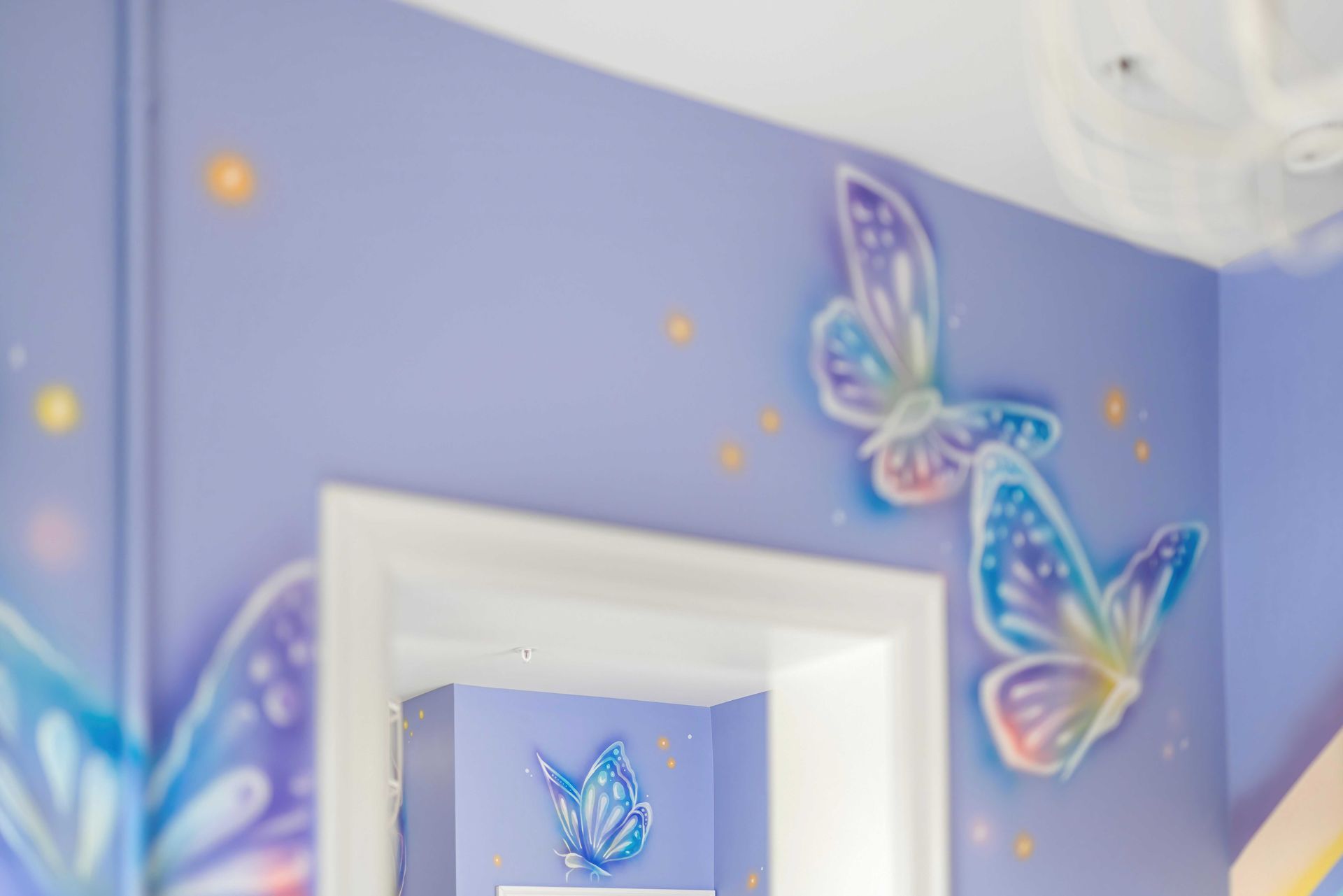 Butterfly wall decals on a lavender wall above a doorway