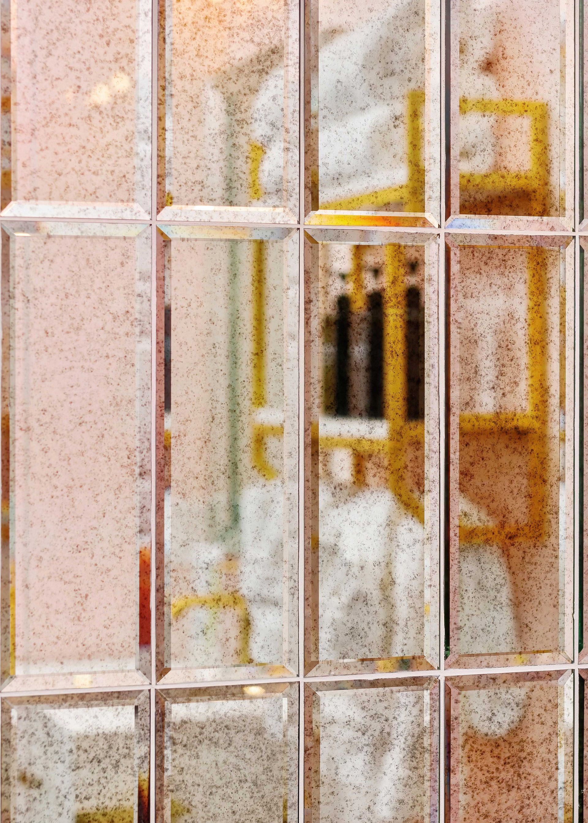 Rain-speckled window bars with a blurred indoor room visible behind them