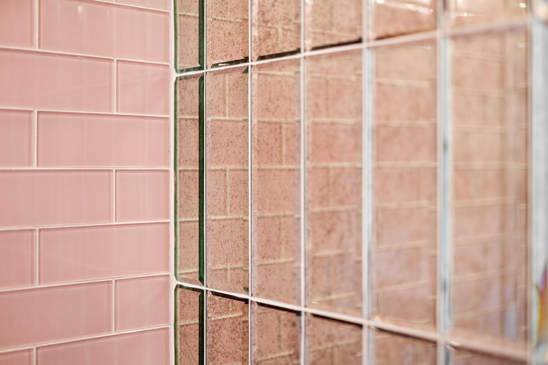 Pink and beige tiled wall seen through a metal fence