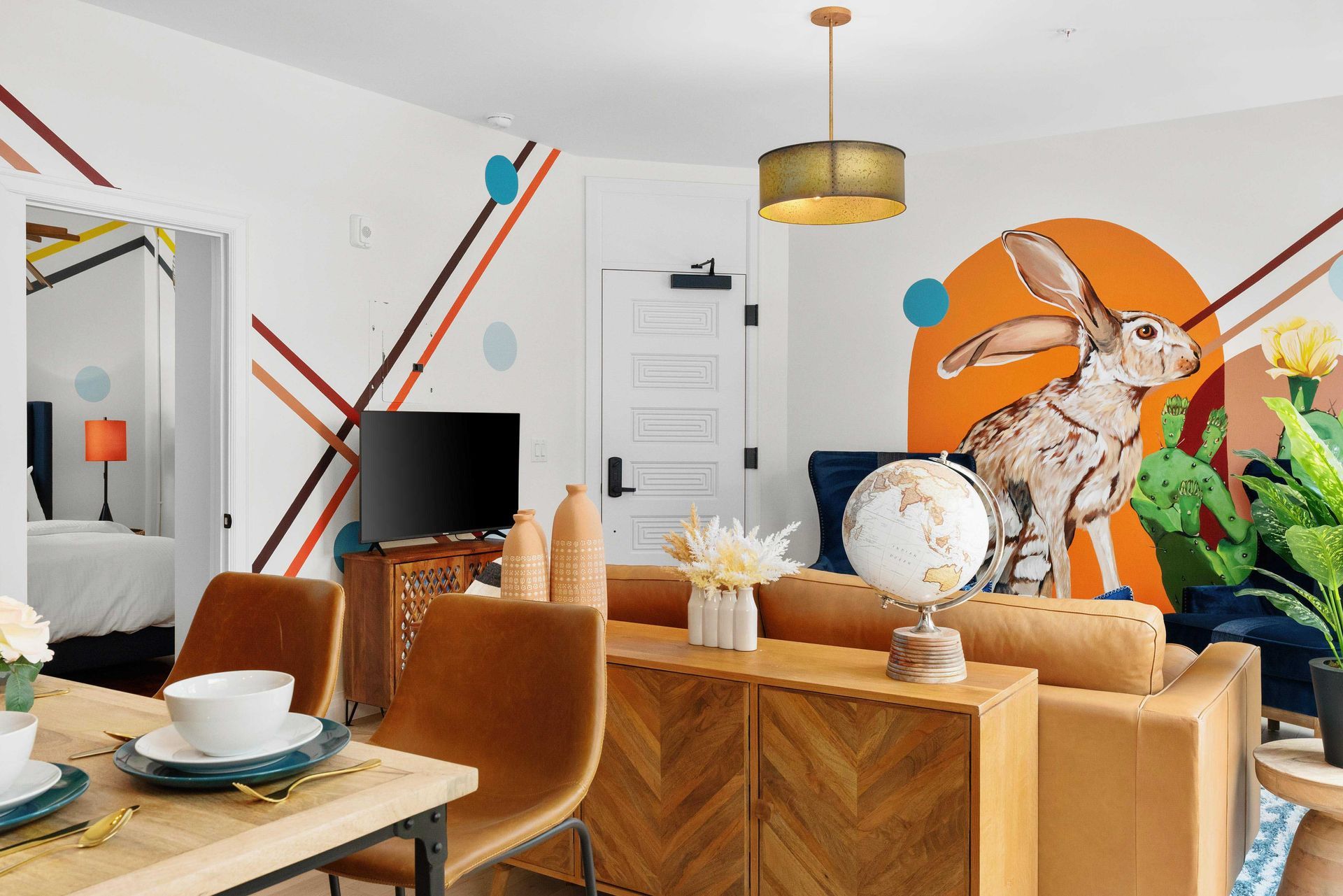 Bright modern dining room with orange mural, wooden table, and tan chairs