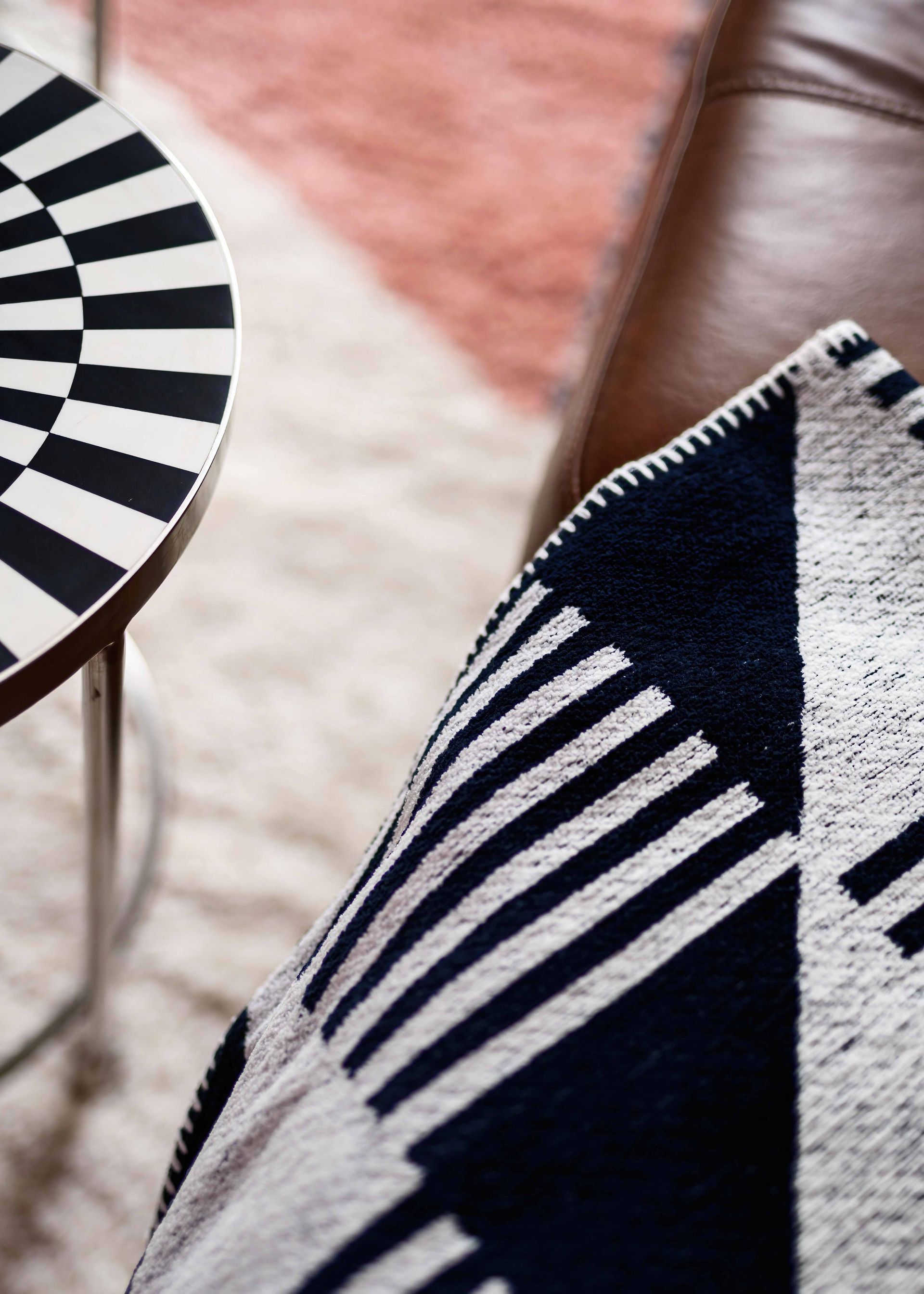 Black-and-white striped chair and patterned cushion in a cozy indoor setting