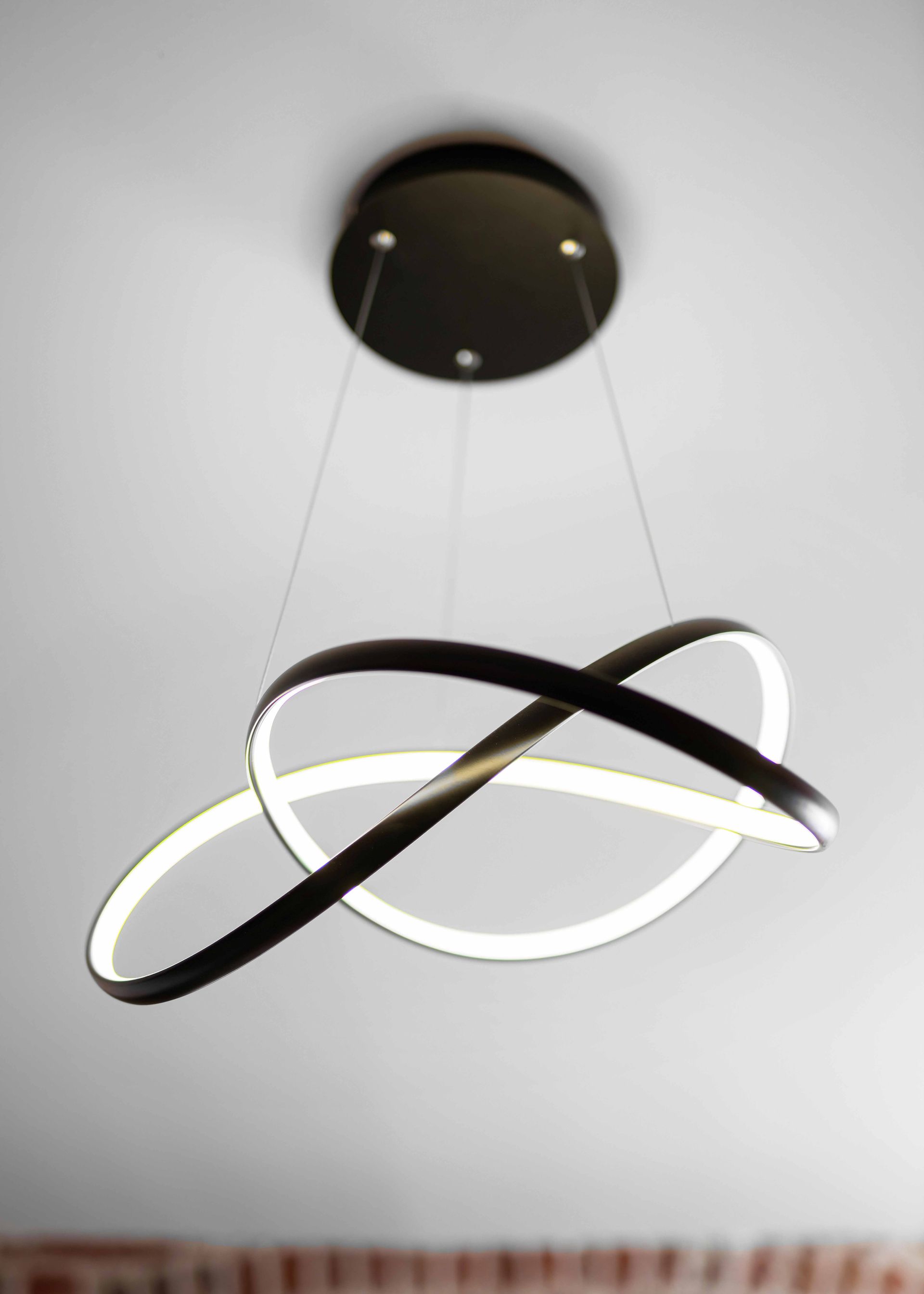 Modern black-and-white ring pendant light hanging from a ceiling