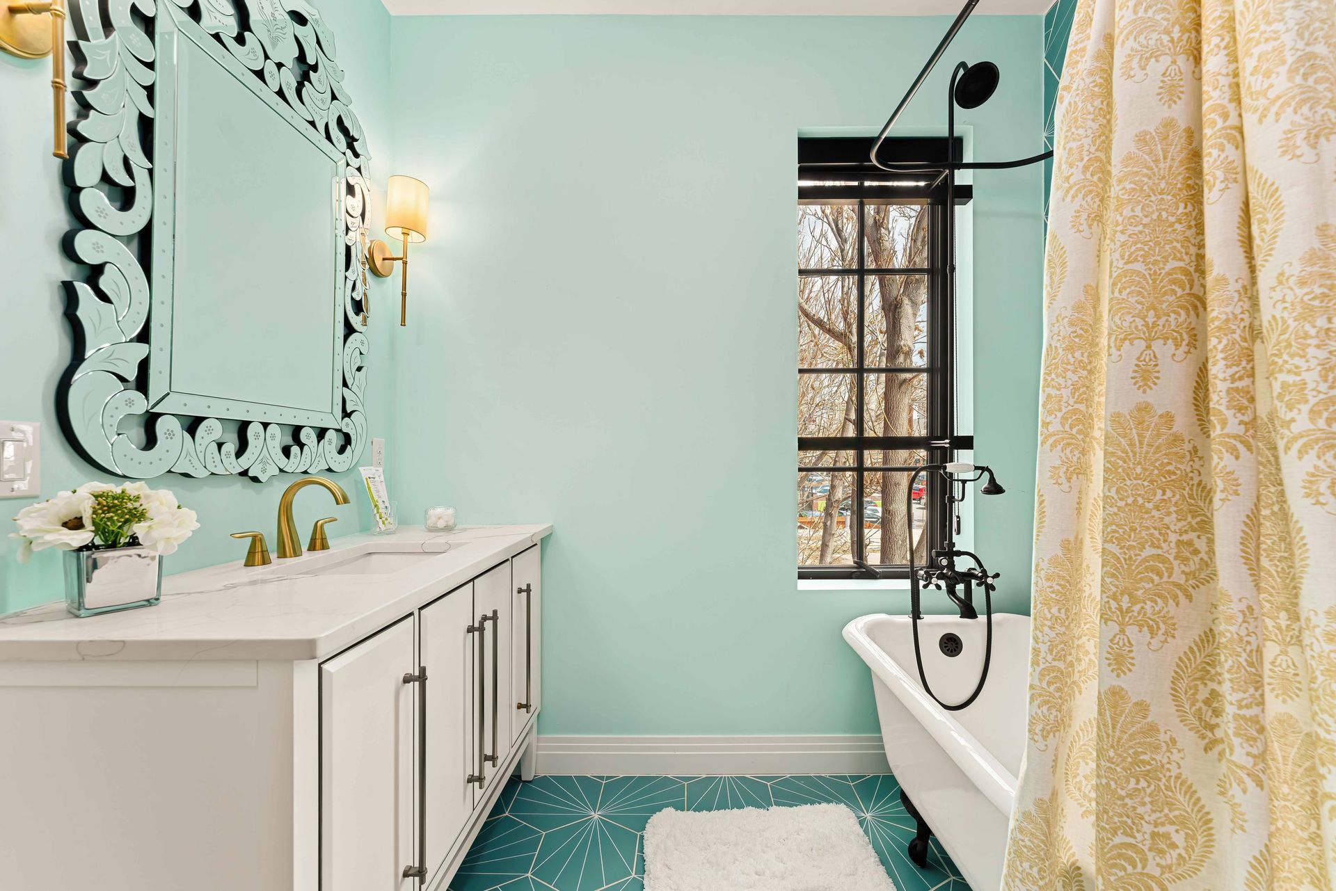 Mint bathroom with white vanity, ornate mirror, freestanding tub, and yellow shower curtain