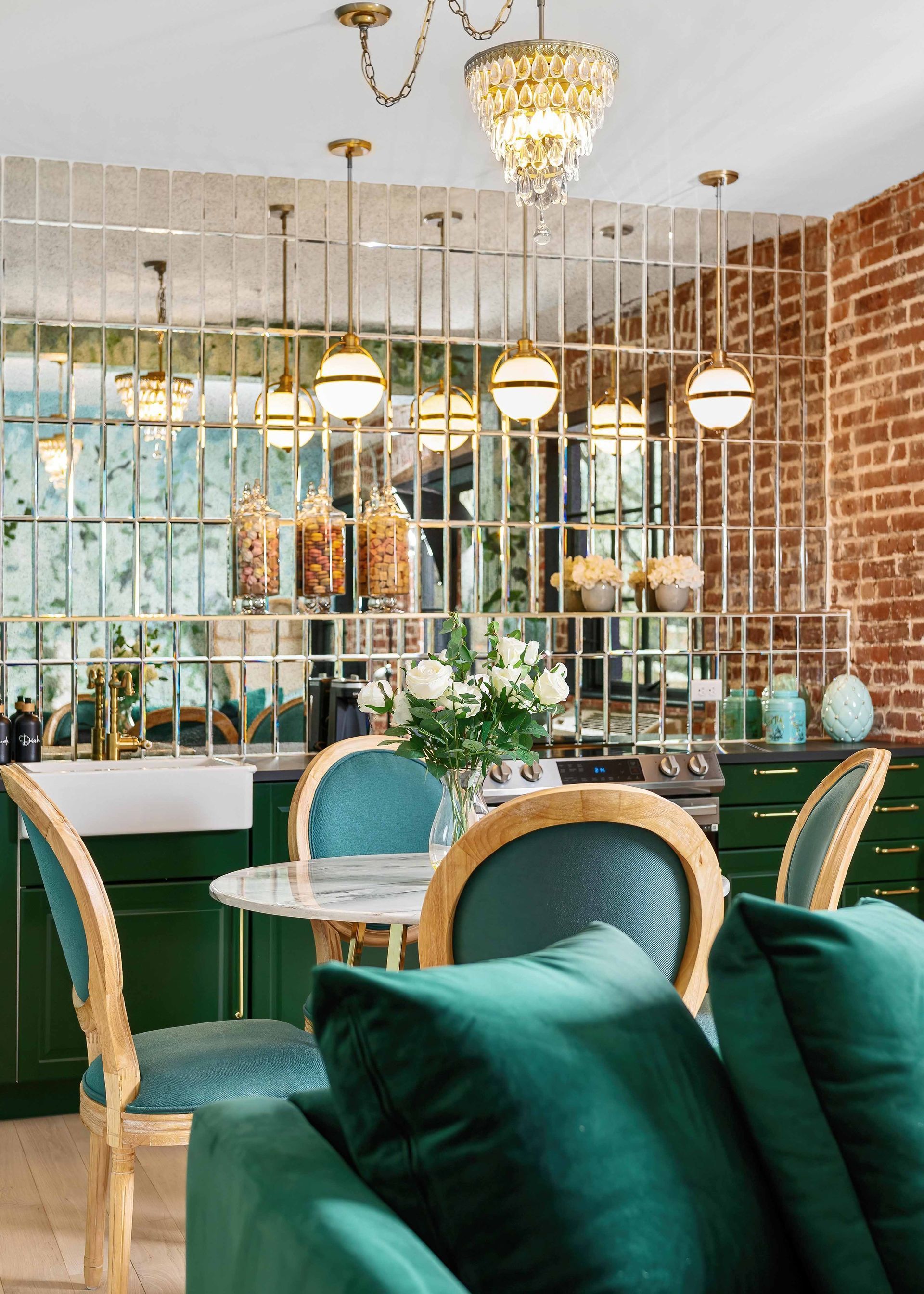 Elegant café interior with teal chairs, round tables, hanging globe lights, and a brick accent wall