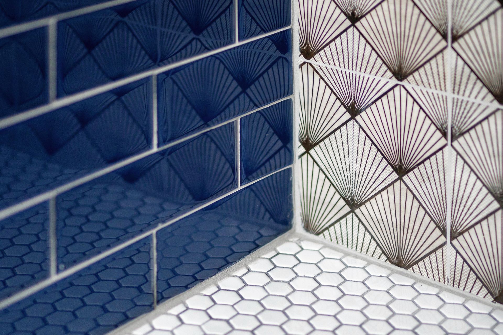Blue and white geometric tiled wall and floor with hexagonal and triangular patterns