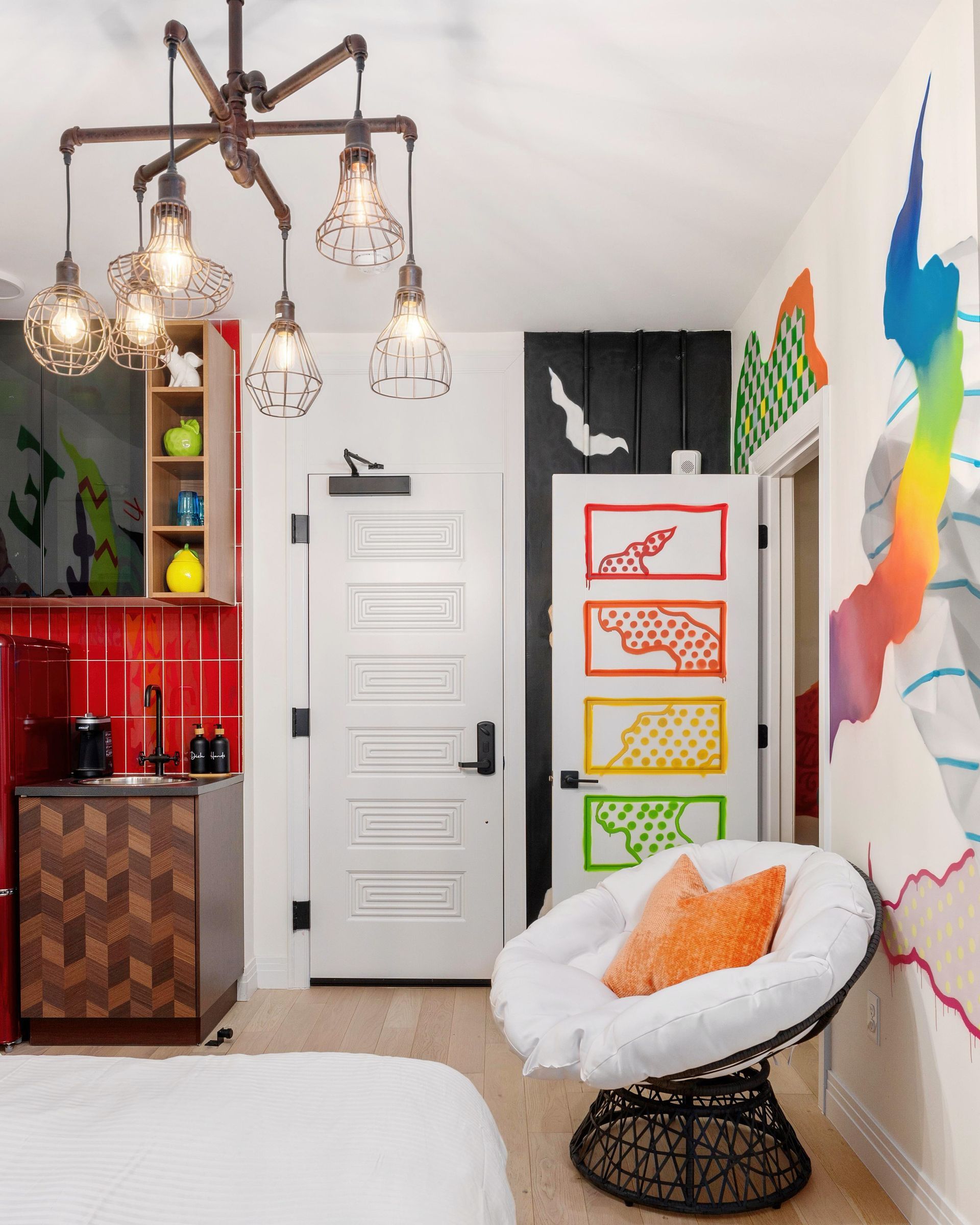 Colorful modern room with hanging lights, white chair, and abstract wall art