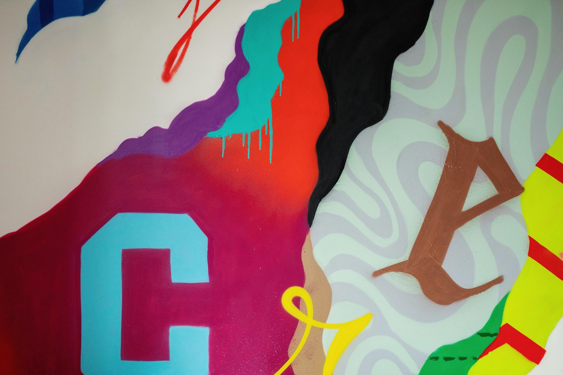 Abstract mural with bold red, purple, teal, and black shapes on a light background