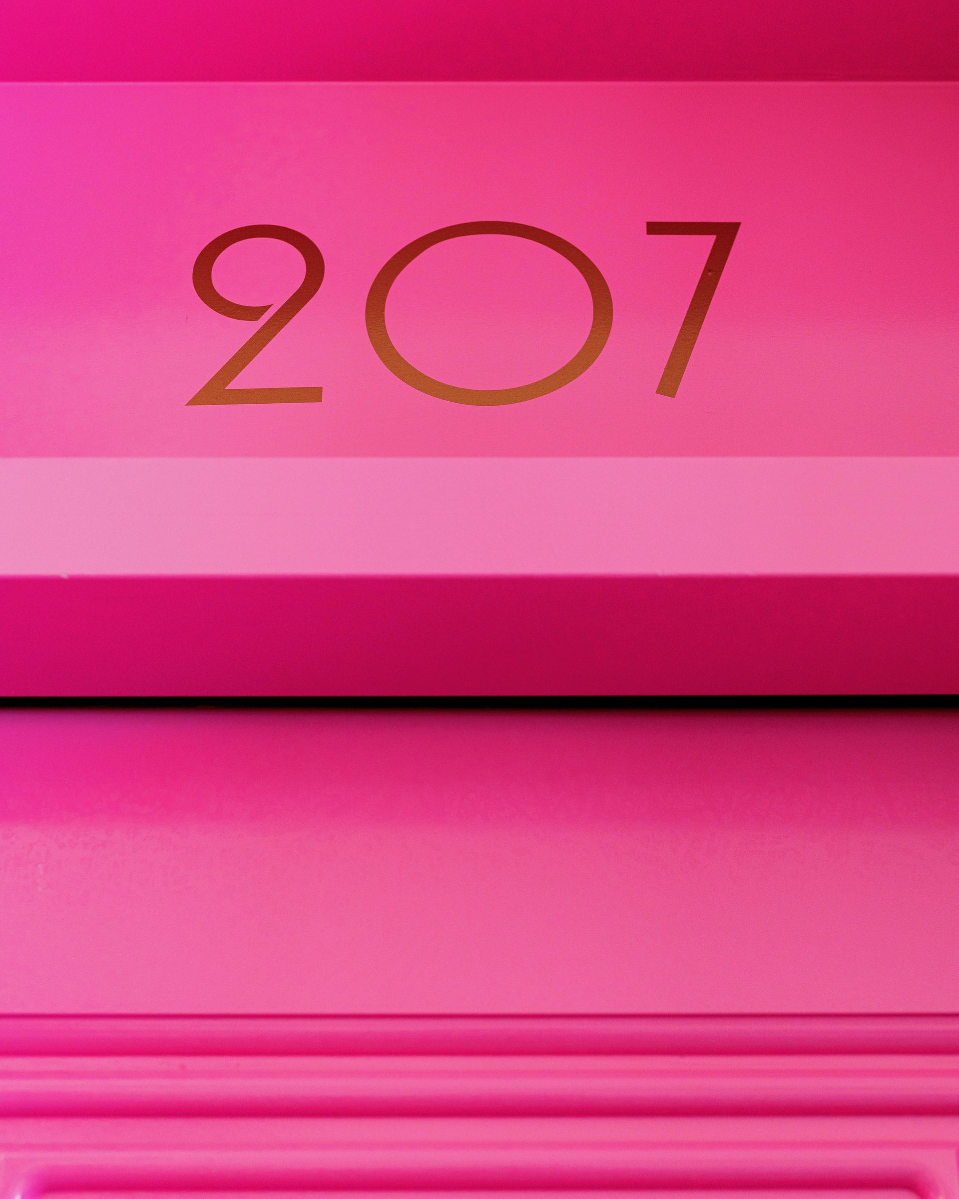 Pink door with gold number 207