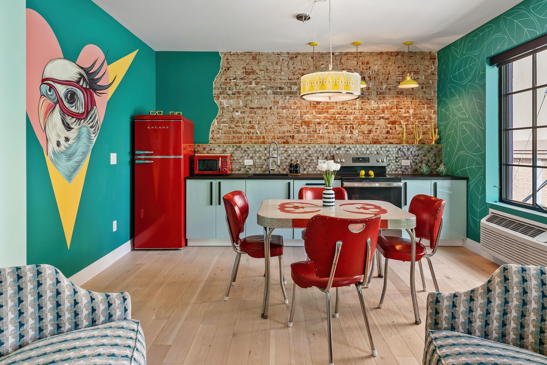 Colorful modern kitchen-dining area with teal walls, red accents, and a dining table set for four