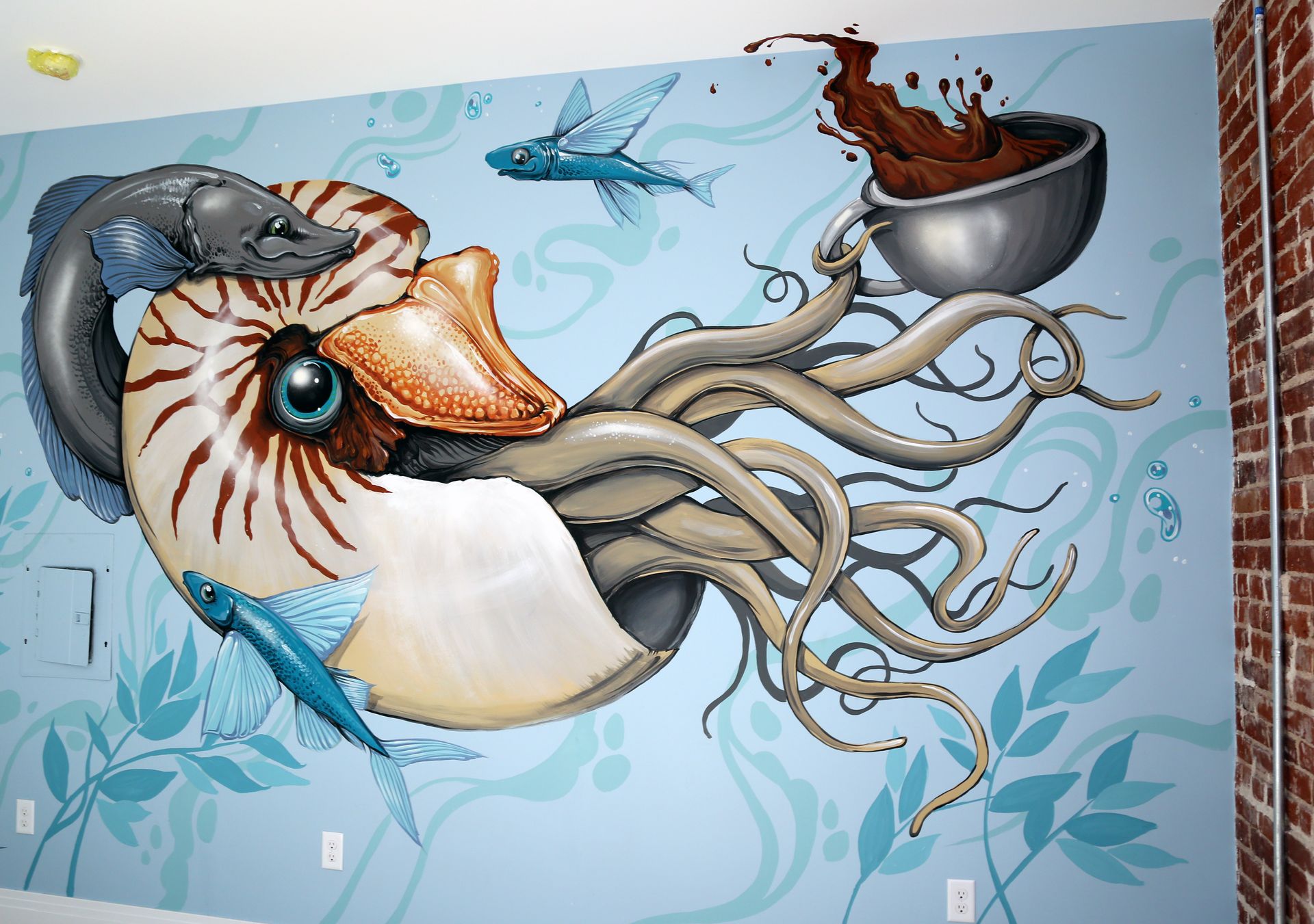 Mural of a giant nautilus with tentacles and a crow perched on its shell, on a blue ocean-themed wall
