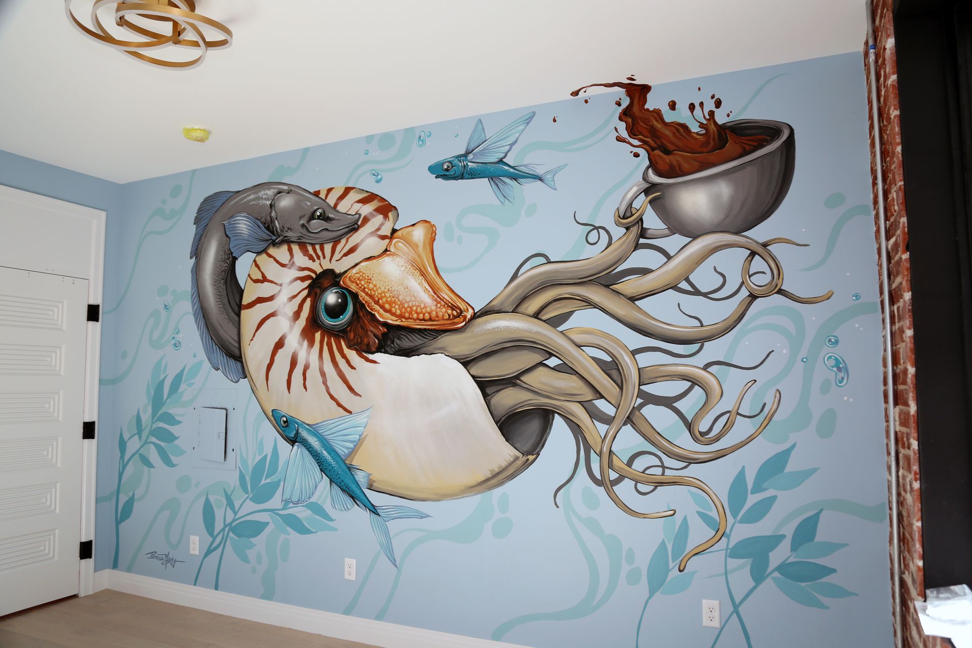 Nautilus and octopus mural in blue tones on a wall inside a room