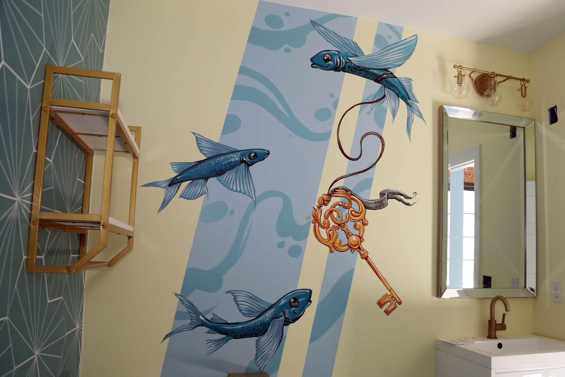 Bathroom wall mural with blue dolphins and a seahorse, beside a mirror and sink.