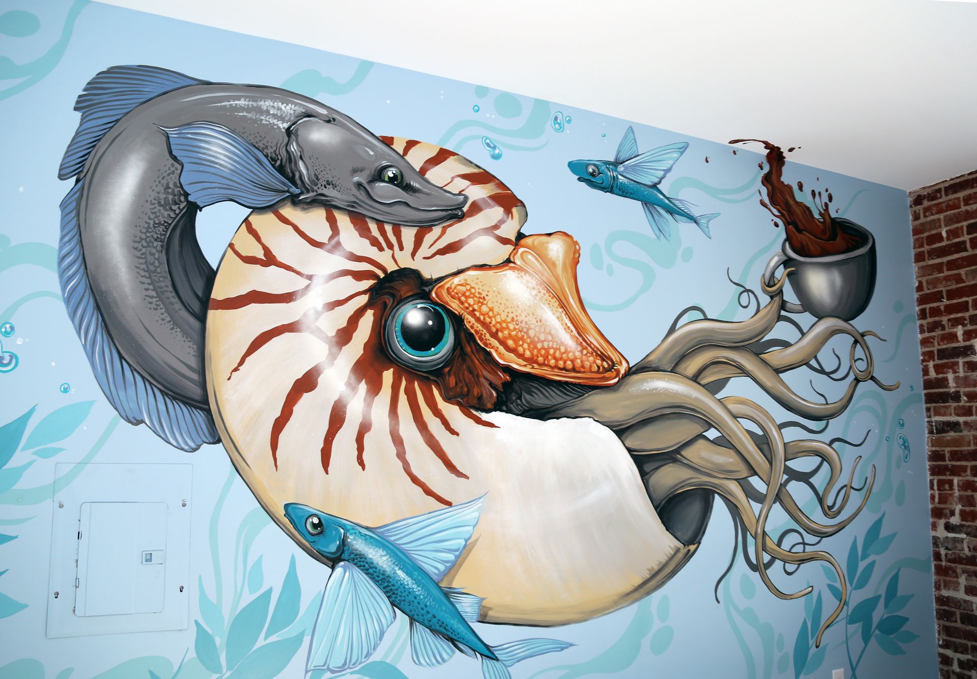 Colorful mural of an octopus, fish, and sea creature on a wall with swirling blue water and bubbles