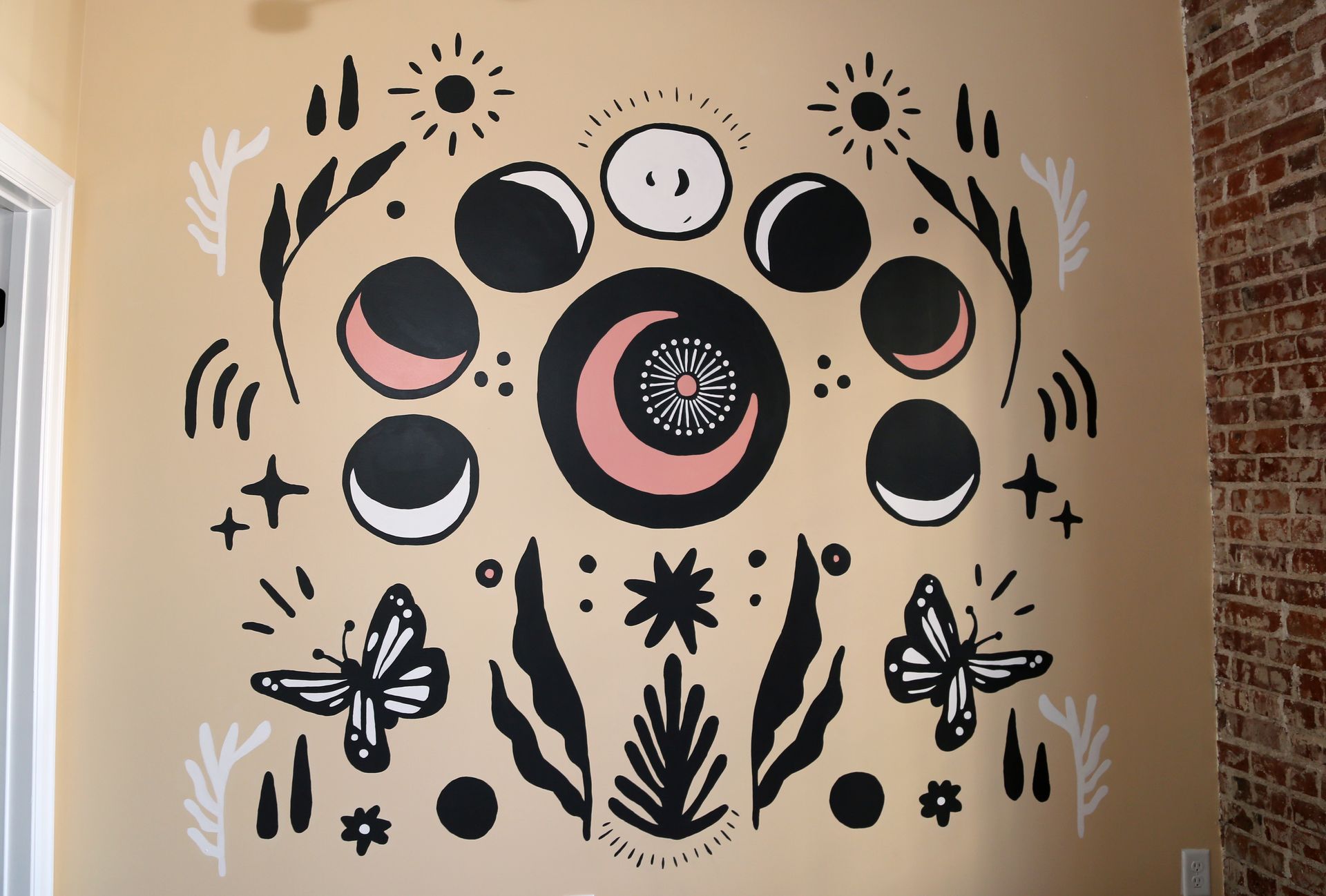 Black and white abstract wall art with moons, suns, stars, and decorative floral motifs