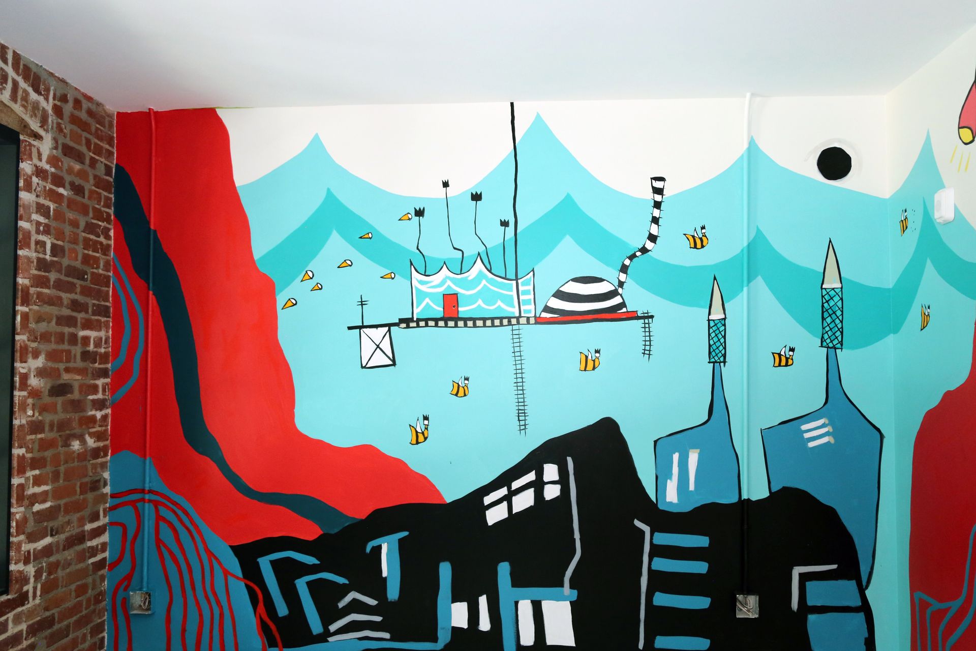 Colorful mural of a harbor scene with boats, cranes, and city buildings in blue, red, and black shapes