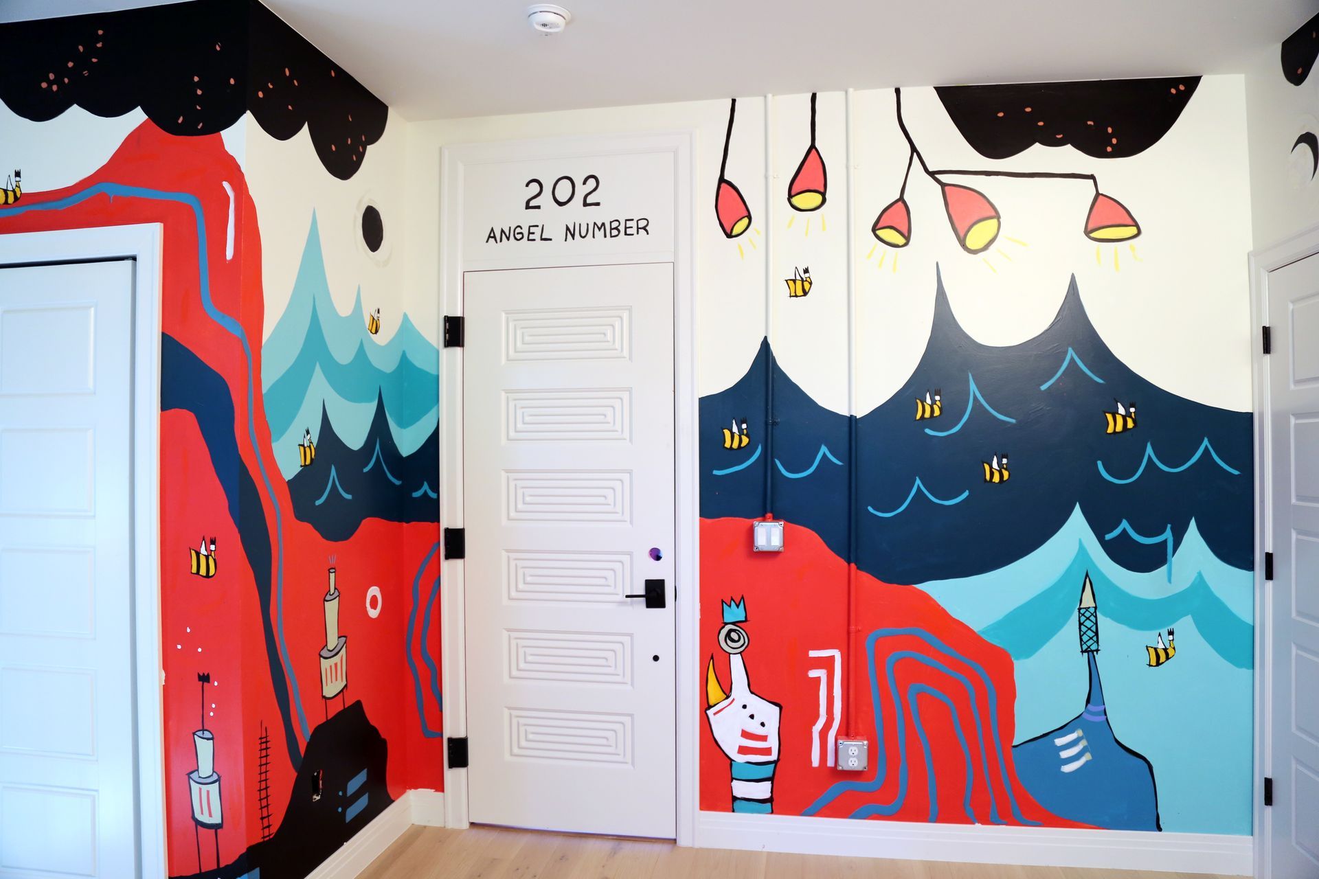 Colorful mural hallway with red, blue, and black waves beside white doors marked 202 and 203