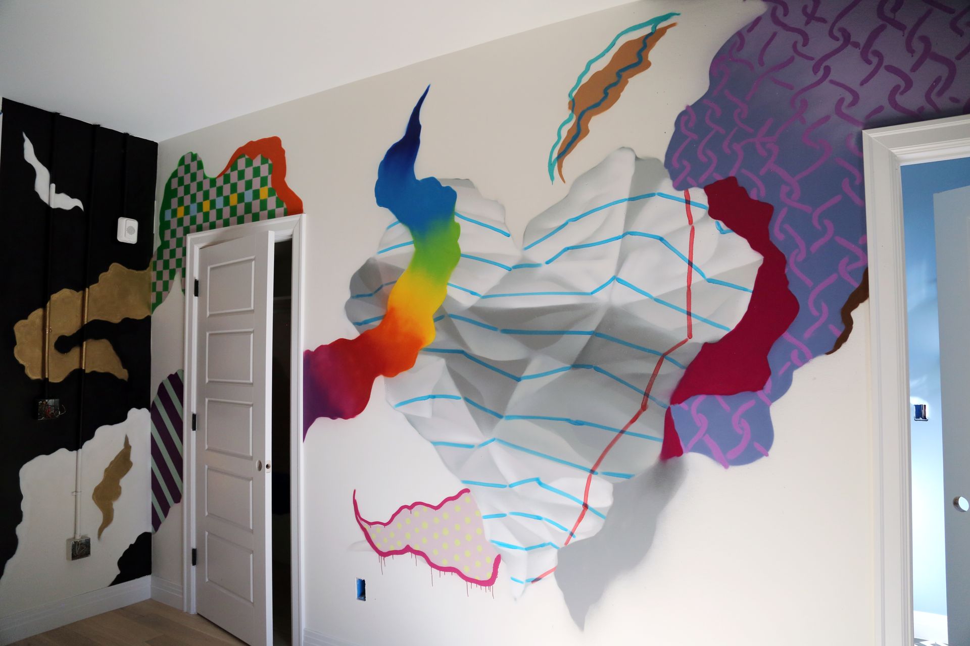 Colorful abstract mural with wavy lines painted on a white wall in a room hallway