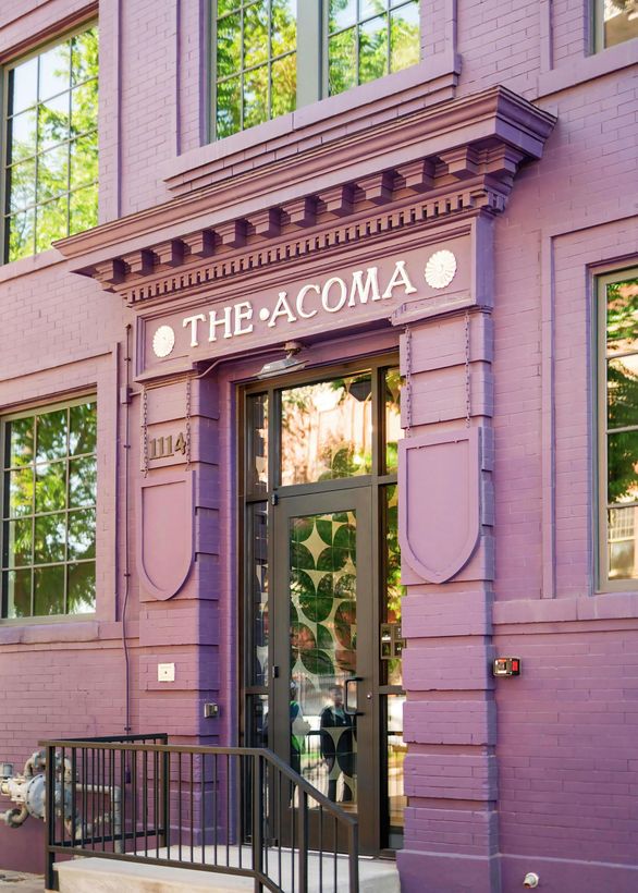 Purple storefront with sign reading “The Acoma” above a glass door and windows